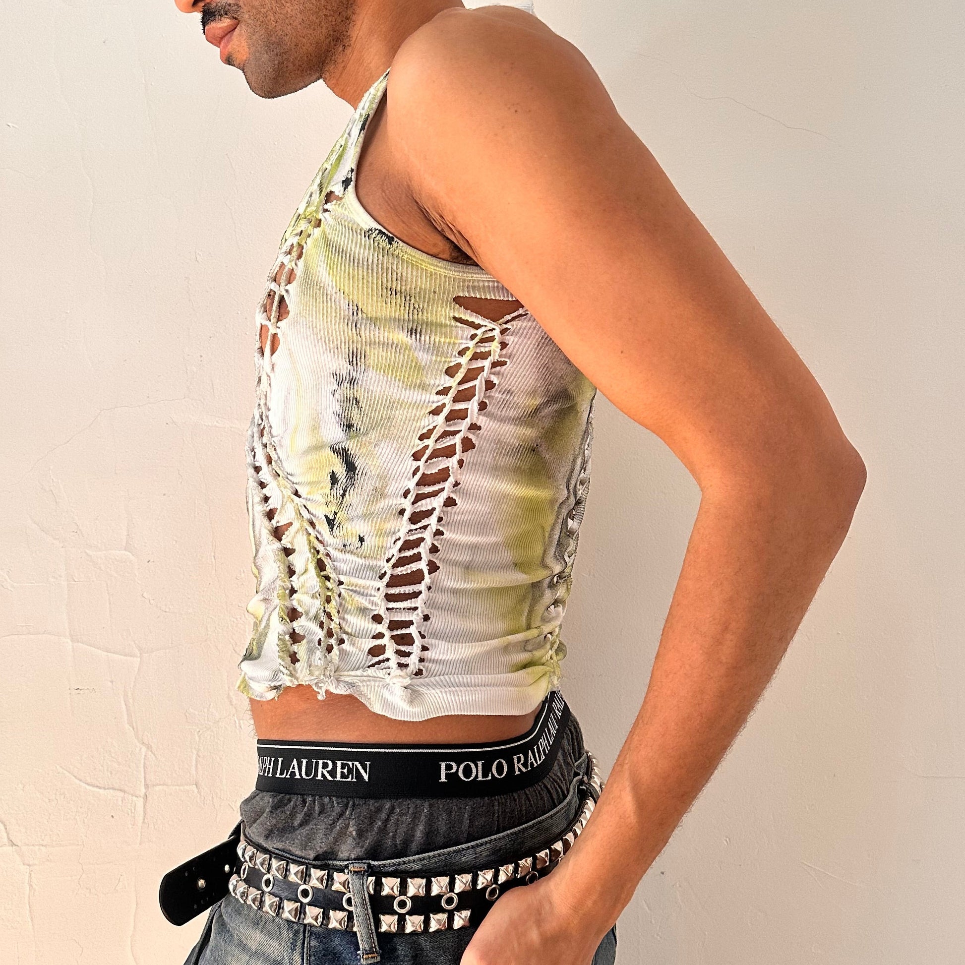 Left side detail of ASTROBOI* x Calvin Klein 'Brat' showing hand-braided arrangement, raw hem, and haze paint design on white mid-weight cotton.