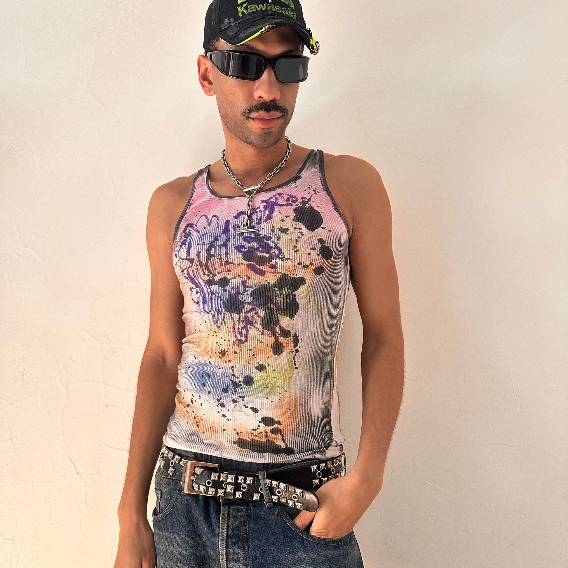 Styled image of ASTROBOI* x Hanes 'Spectrum' white slim-fit tank top with hand-painted multicolored graffiti graphic print throughout, customized at ASTROBOI* STUDIO in NYC.