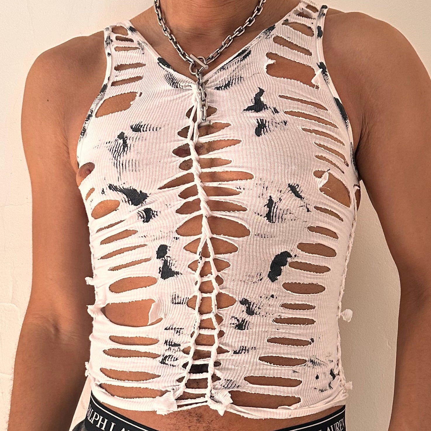 Close-up of ASTROBOI* 'Yin Yang' showing hand-braided construction, slash and knot detailing, and black paint smudges on white cotton fabric.