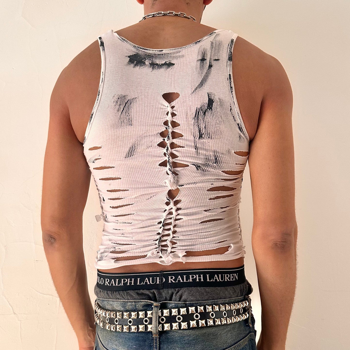 ASTROBOI* 'Marble' white braided painted twist tank top, rear view showing braid, slash, and paint detail construction, worn by male model.