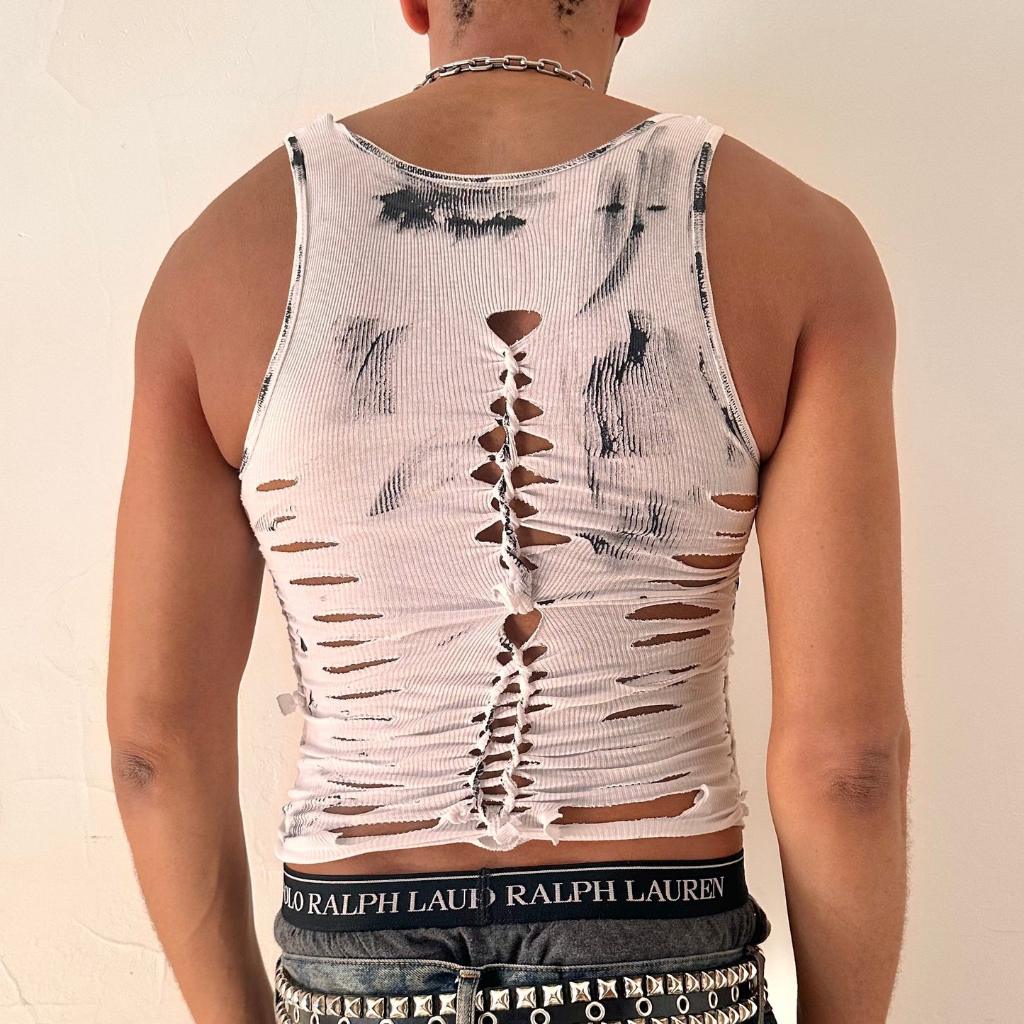 ASTROBOI* 'Yin Yang' white and black braided twist tank top, rear view showing braid, slash, knot, and paint detail construction, worn by model.
Ready for the next piece.