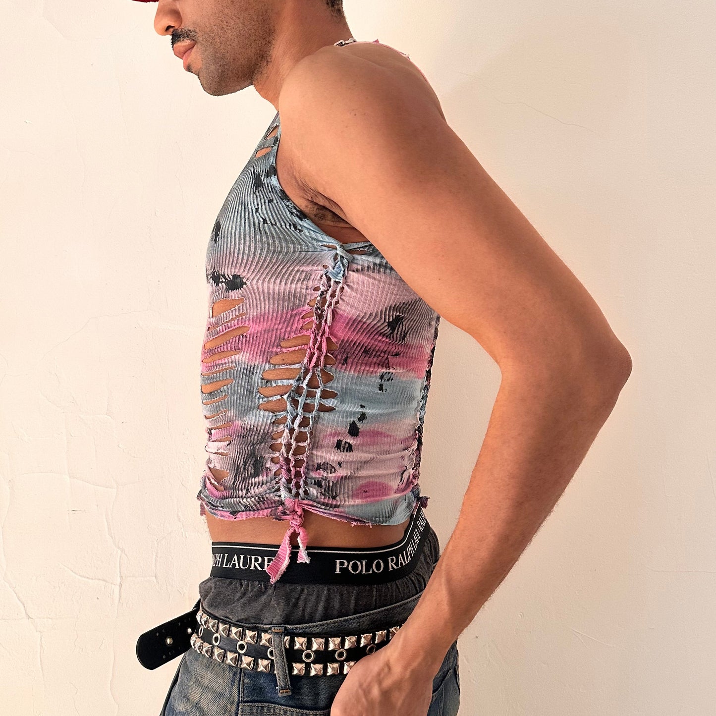 Left side detail of ASTROBOI* x Fruit of the Loom 'Sunrise' showing hand-braided arrangement and black tar paint detailing on pink and blue tie dye tank.