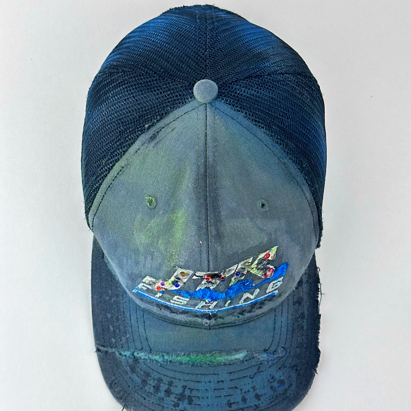 ASTROBOI* 'JFK Fishing' gray rhinestone trucker cap with rhinestone-embellished embroidered logo, blue wave design, and deconstructed visor, top view.