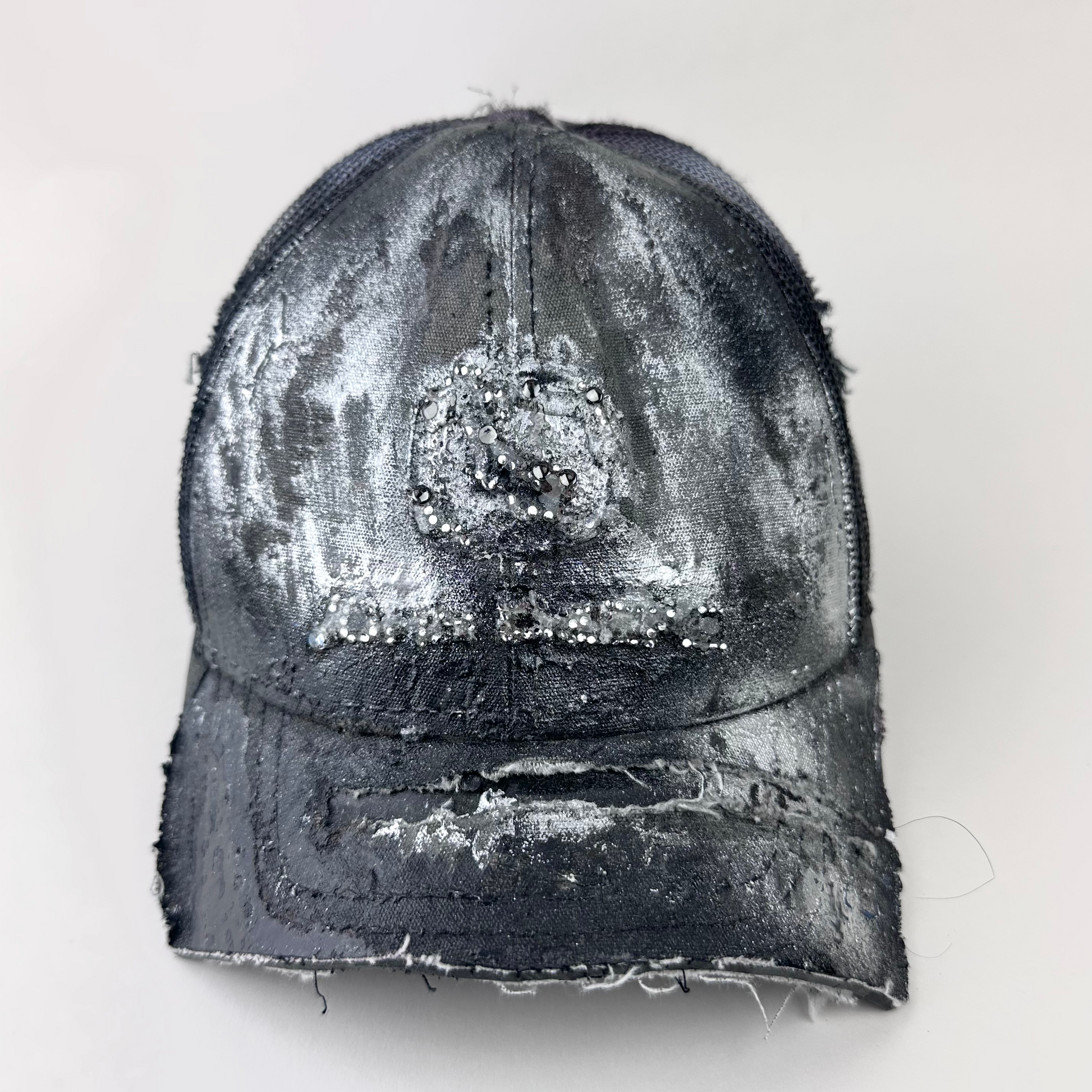 ASTROBOI* x John Deere 'Silver Surf' black digital camo trucker hat with silver tonal rhinestone-embellished John Deere logo and partially sawed-off deconstructed visor, front view.