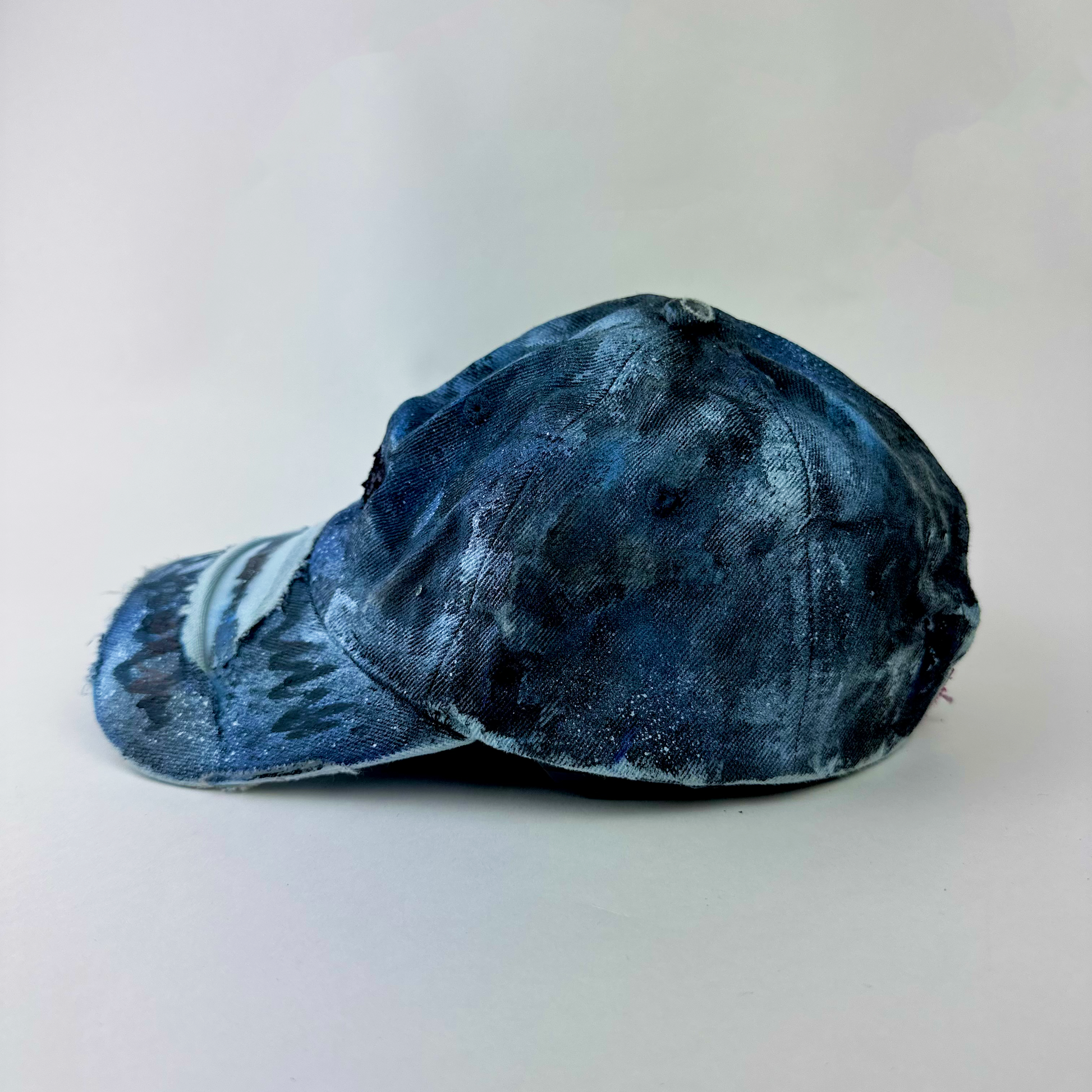 Left side detail of ASTROBOI* x Levi's 'Blacked Out' showing custom paint treatment and distressed denim detail on grunge hat.