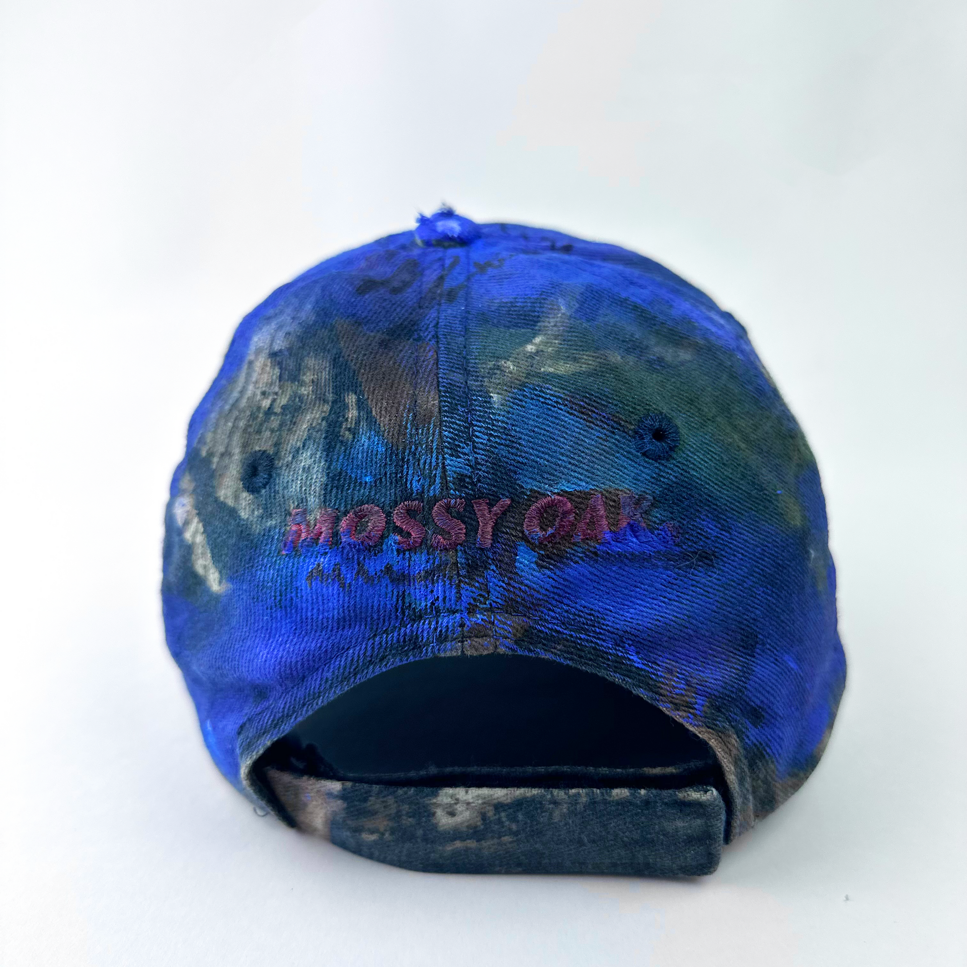 ASTROBOI* x Mossy Oak 'Ultraviolet' brown and purple camouflage hat, rear view showing embroidered Mossy Oak back logo detail and adjustable strap.