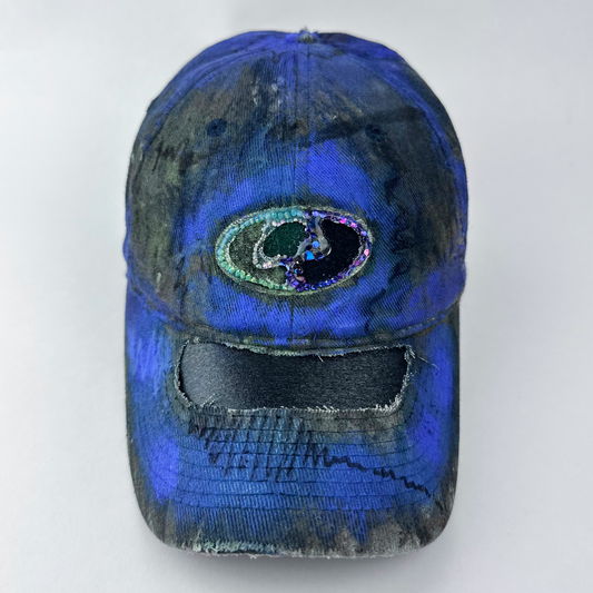 ASTROBOI* x Mossy Oak 'Ultraviolet' brown and purple Real Tree camouflage hat with rhinestone-embellished Mossy Oak logo at front, ultraviolet flowing paint treatment, and deconstructed visor, front view.