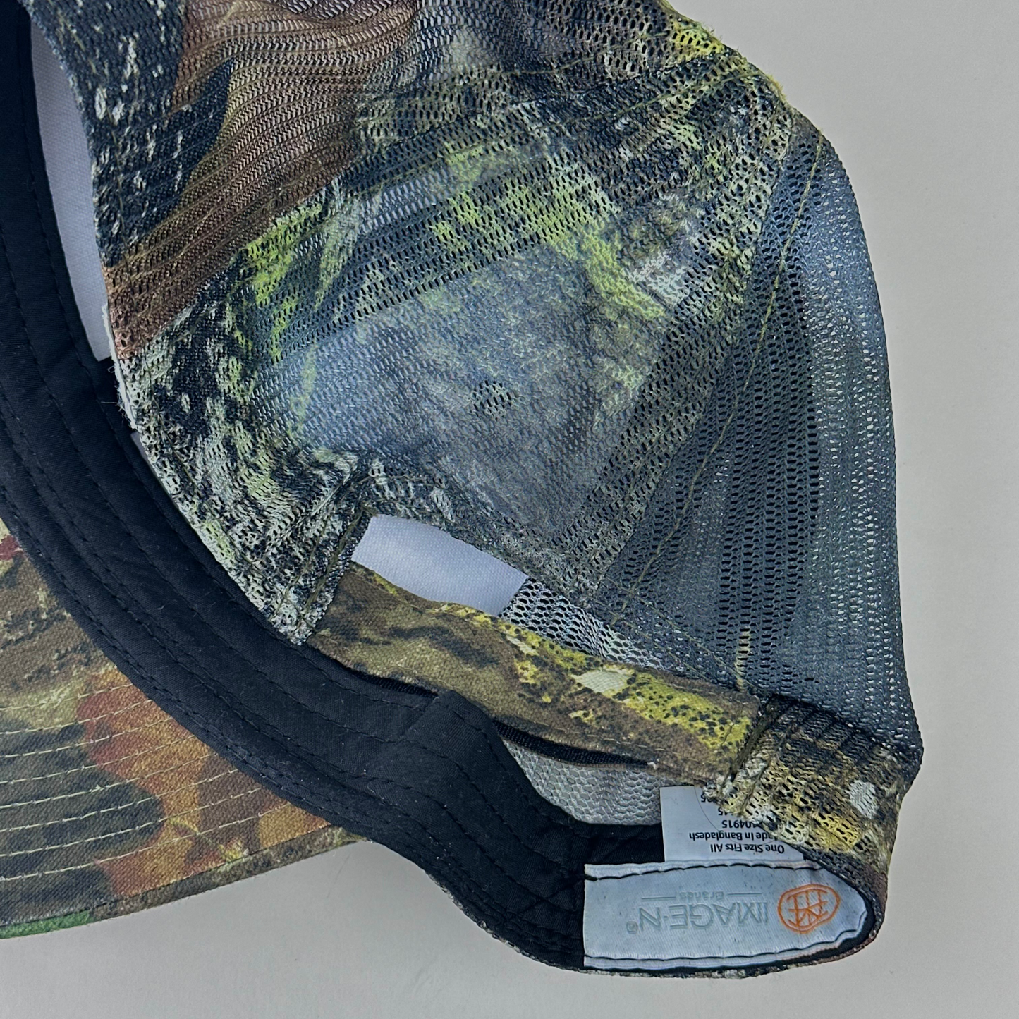 ASTROBOI* 'Mountains' brown Real Tree trucker hat, rear view showing mesh back panel and adjustable strap.