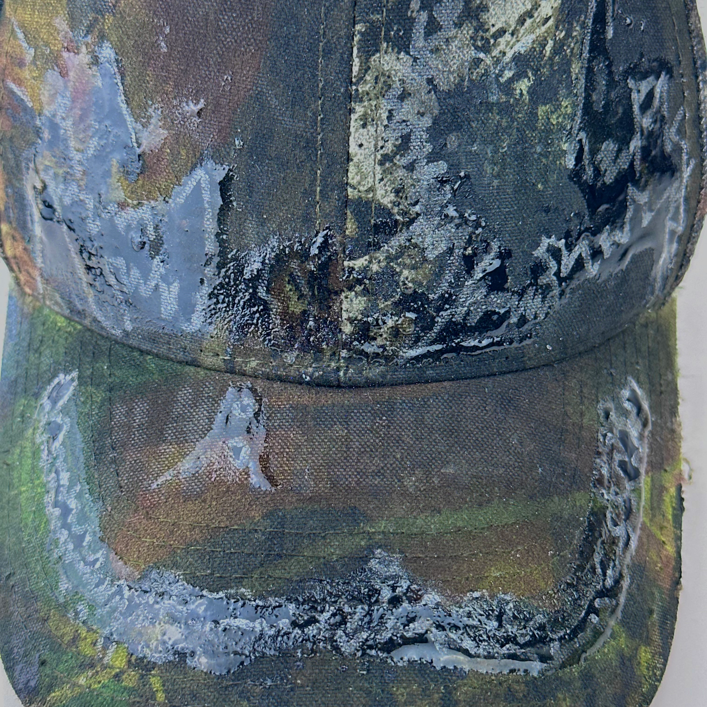 Close-up of ASTROBOI* 'Mountains' showing hand drawn black and silver design detail sealed under clear resin on Real Tree camouflage fabric.