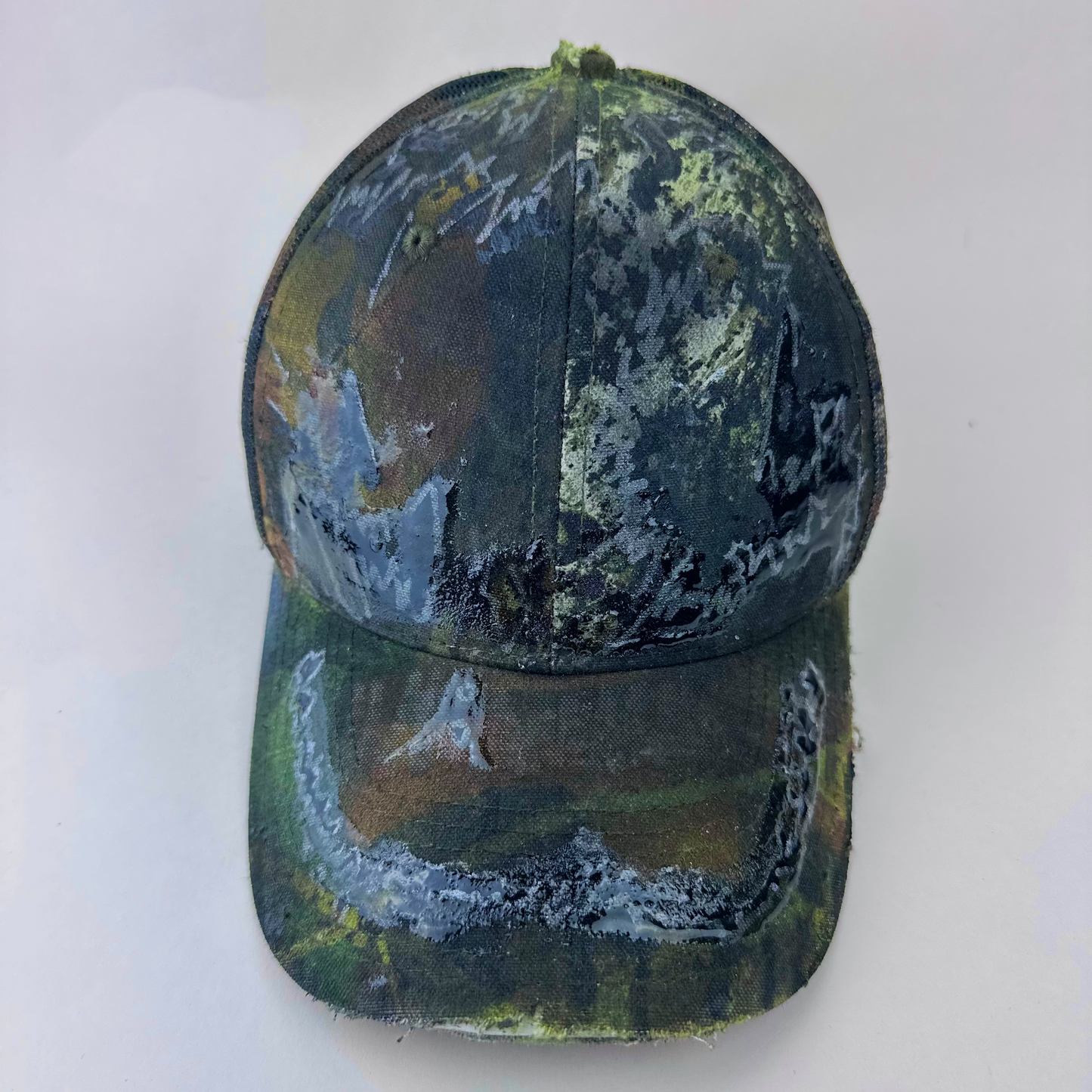 ASTROBOI* 'Mountains' brown Real Tree camouflage trucker hat with hand drawn black and silver design sealed under clear resin at front, front view.