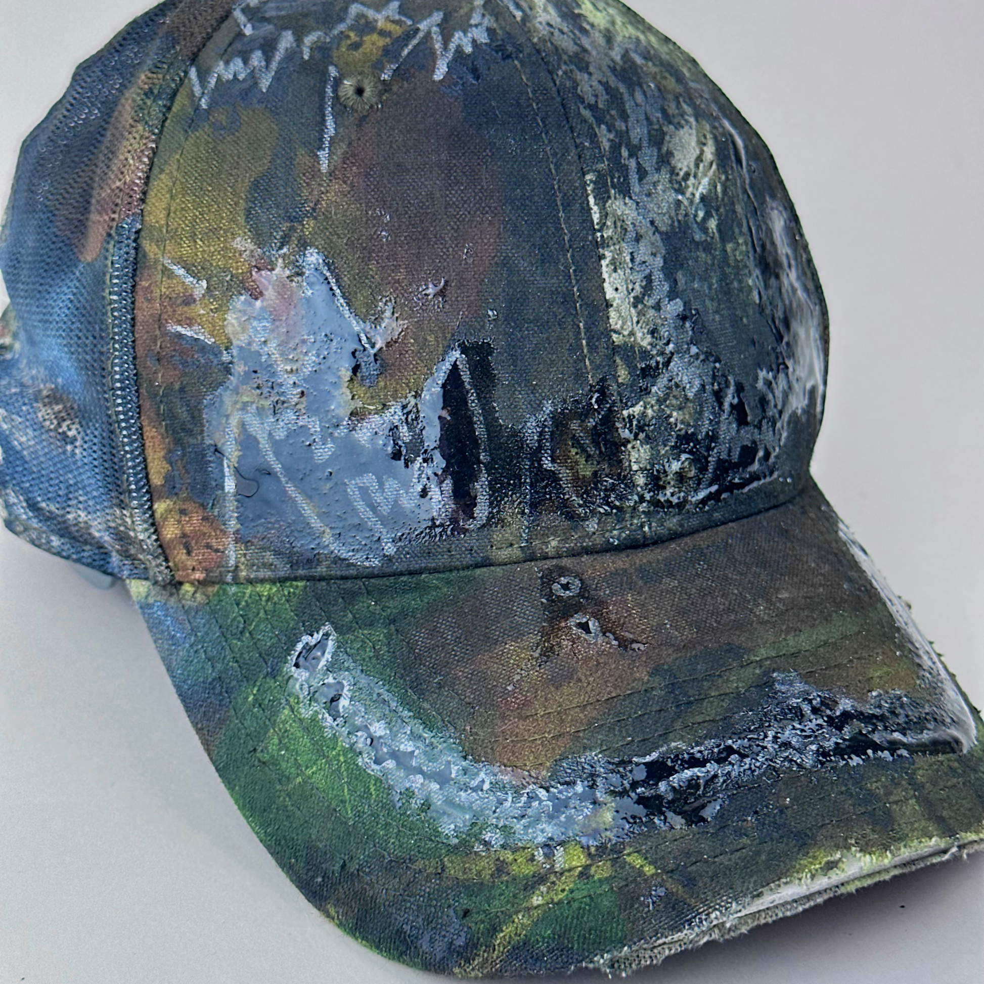 Close-up of left side detail on ASTROBOI* 'Mountains' showing hand drawn black and silver design detail sealed under clear resin on Real Tree camouflage fabric.