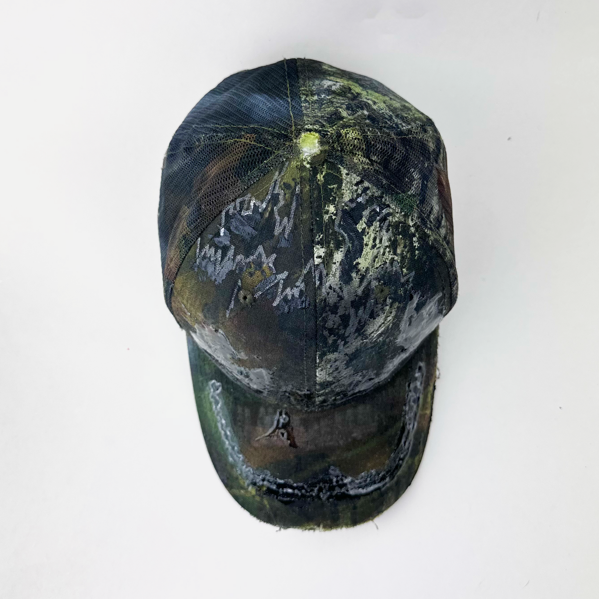 Top view of ASTROBOI* 'Mountains' showing hand drawn resin-sealed design and Real Tree camouflage detail on brown trucker hat.