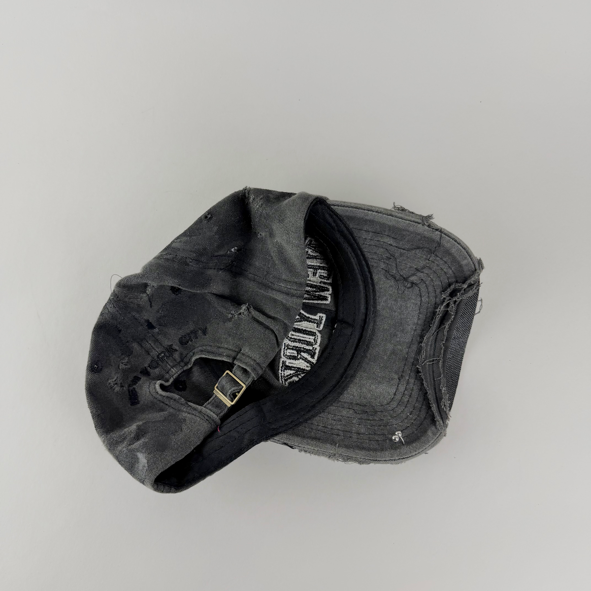 ASTROBOI* 'New York Grunge' black pierced distressed hat, rear view showing adjustable strap back.