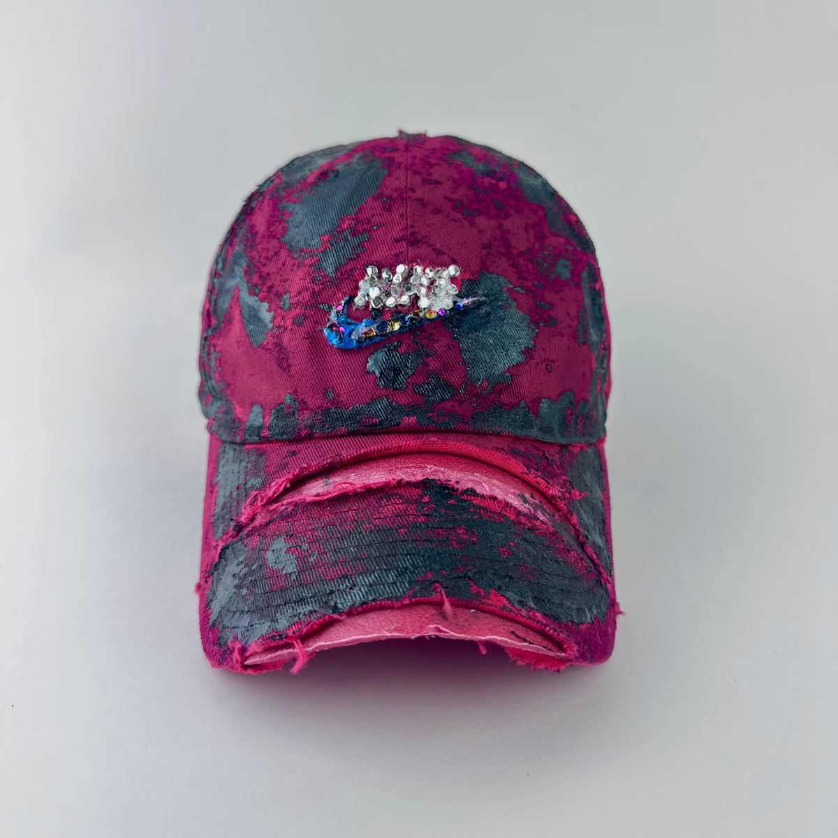 ASTROBOI* x Nike 'Comet' red and black painted distressed hat with Nike logo at center front, black painted pattern, and silver and multicolored rhinestones encased in clear resin, front view.