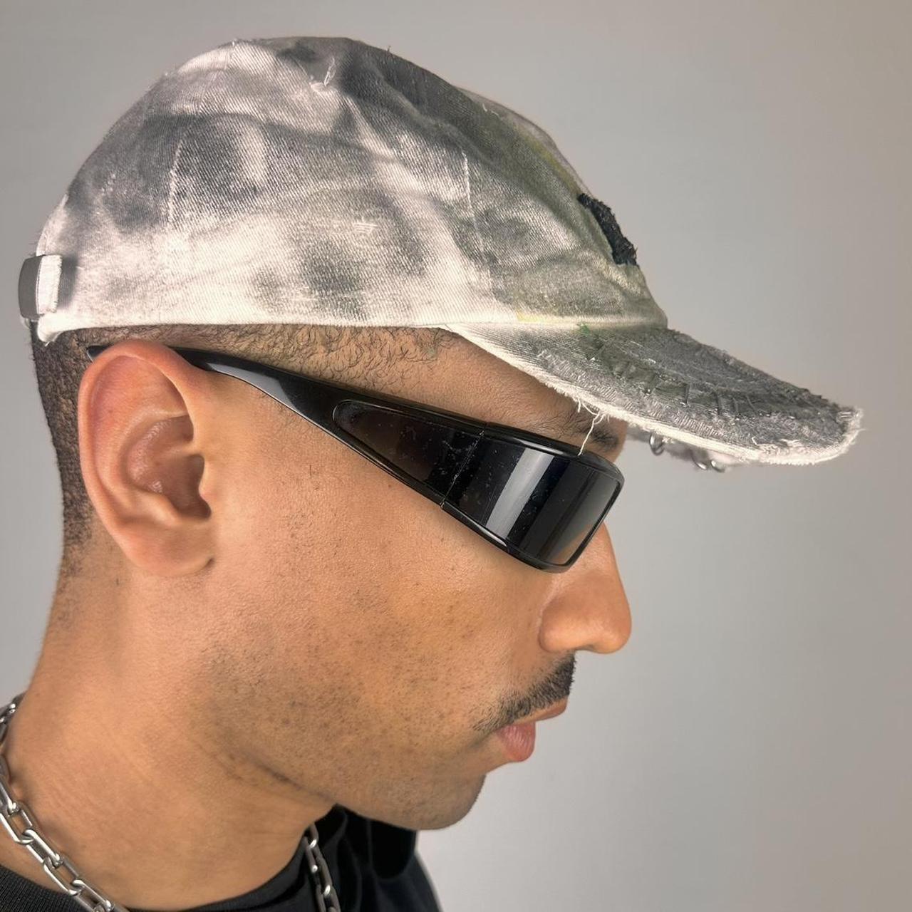 Right side of ASTROBOI* white NYC dad hat with clear resin logo, black and green abstract paint details, adjustable strap back