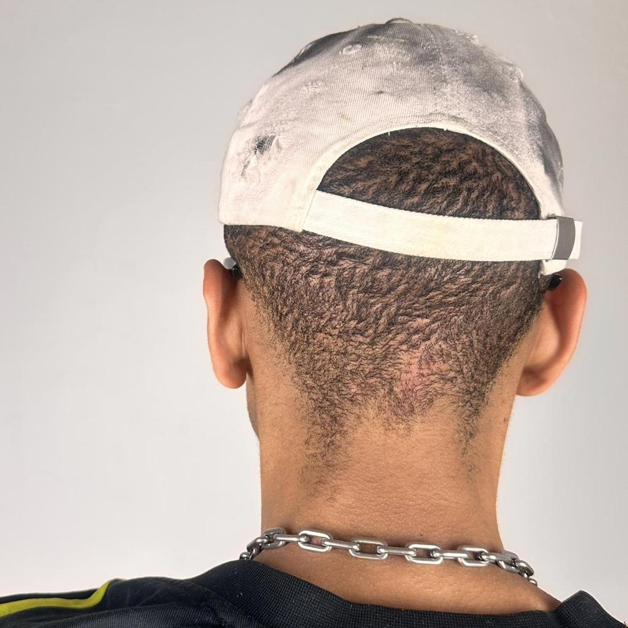 Back of ASTROBOI* white NYC dad hat with clear resin logo, black and green abstract paint details, adjustable strap back