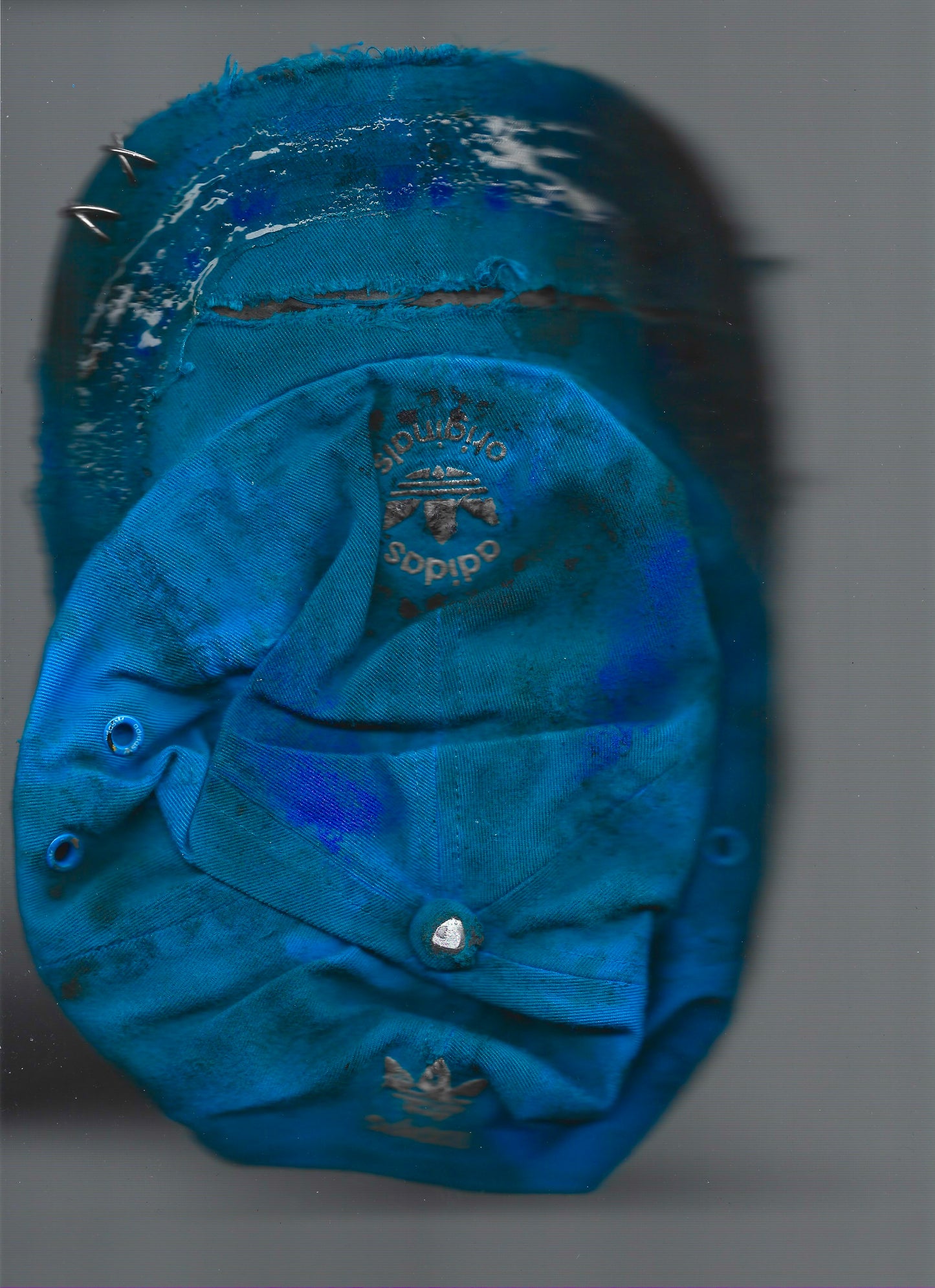 Scanned image of ASTROBOI* x Adidas 'Nebula' blue distressed pierced hat, back view showing white Adidas back logo and adjustable strap.