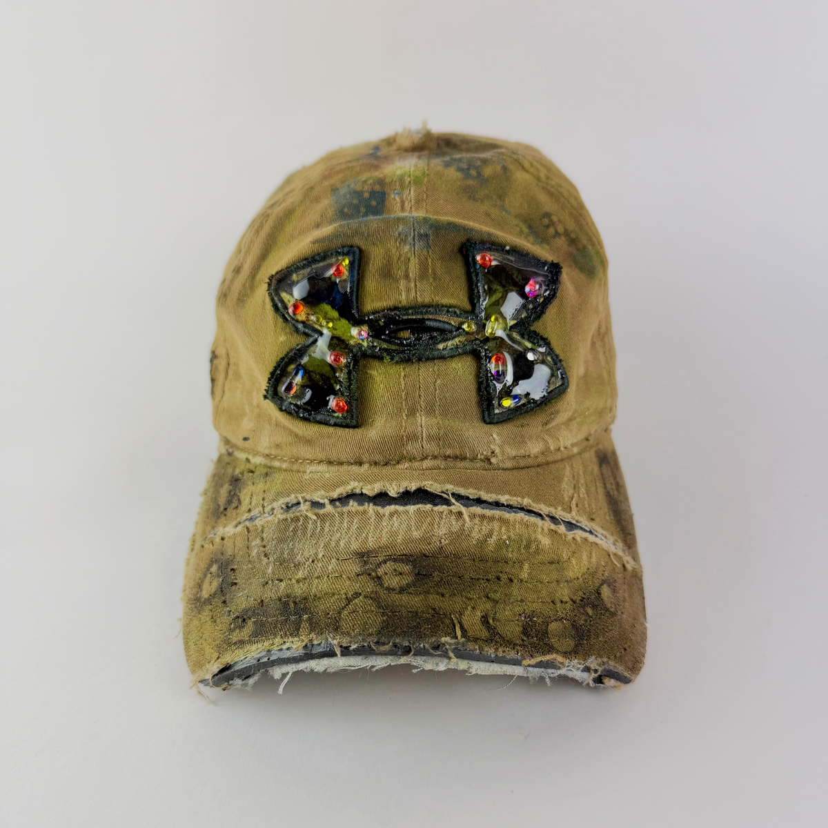 ASTROBOI* x Under Armour 'Dolor' tan distressed rhinestone cap with embellished UA logo and partially deconstructed brim.
