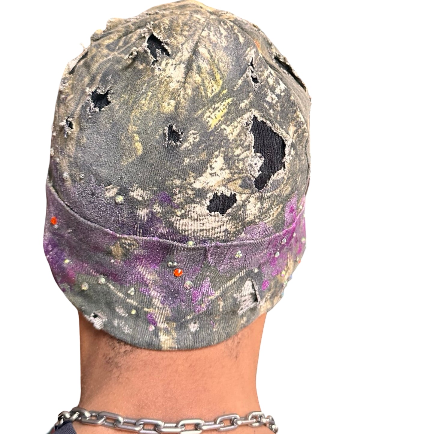 Back side of ASTROBOI* brown RealTree grunge beanie with ripped details, lavender and magenta paint, and colorful rhinestones, handmade in NYC.