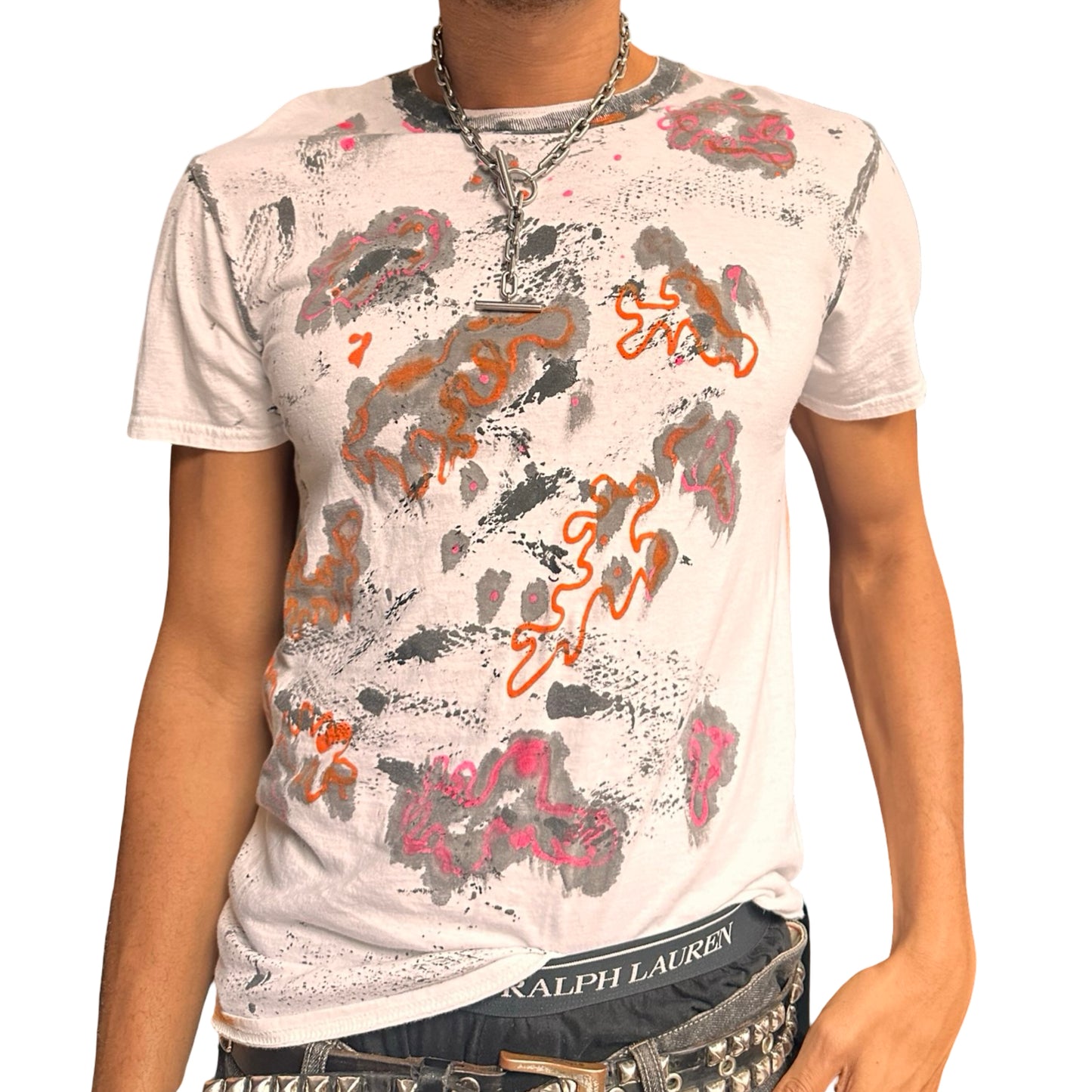 Person wearing a white t-shirt with colorful abstract designs on a plain background