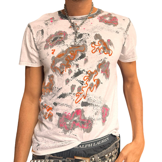 Person wearing a white t-shirt with colorful abstract designs on a plain background