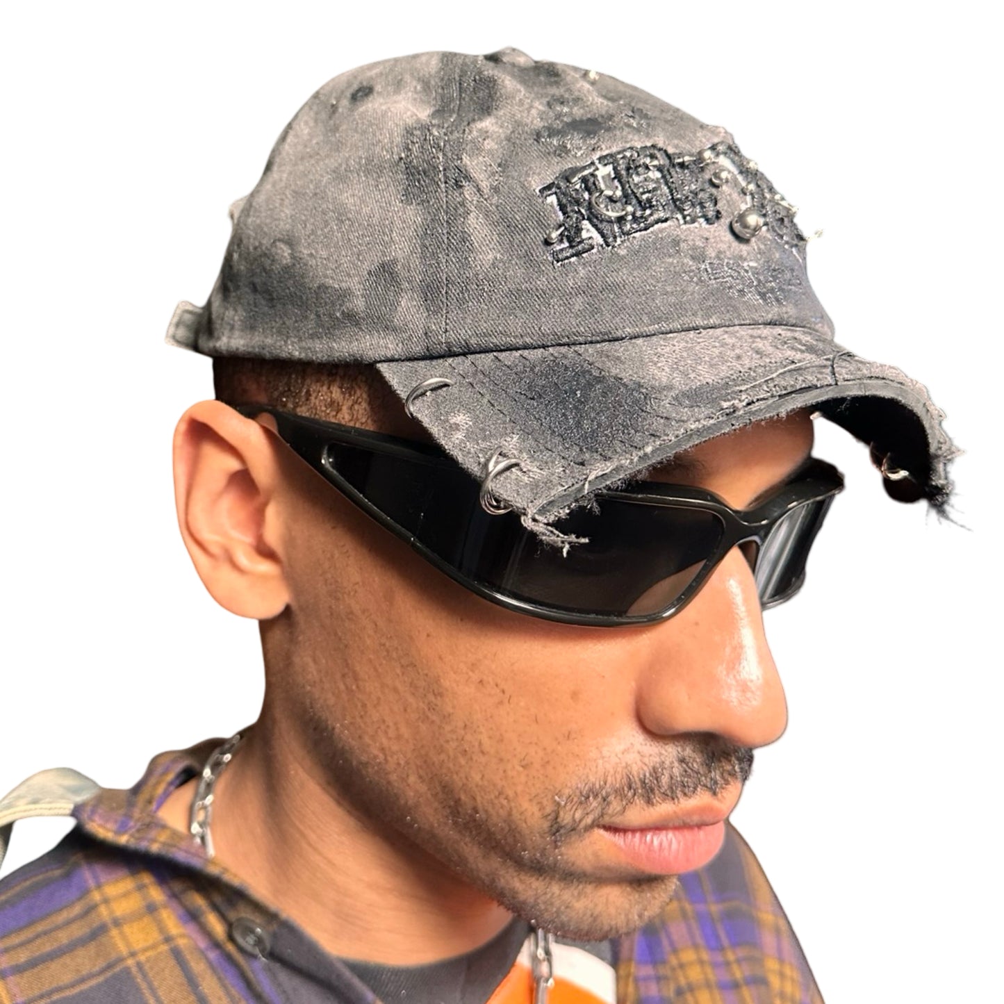 Front right of Black half-visor “New York” hat with embroidered front logo, stainless steel piercings, and an adjustable strap.