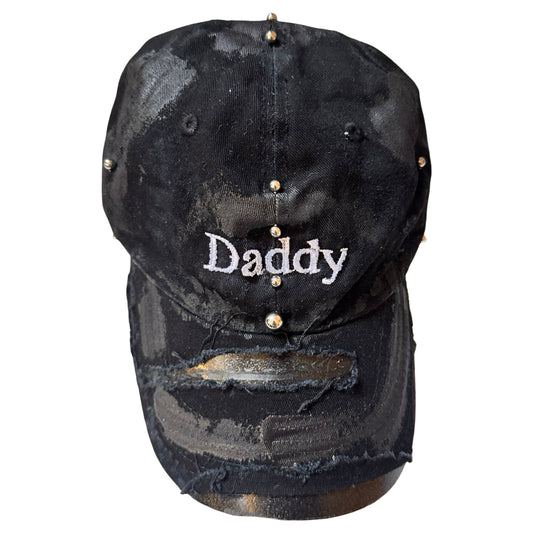 Overview of Black distressed ASTROBOI* ‘Daddy’ hat with custom paint detailing and stainless steel piercings, handcrafted in NYC.