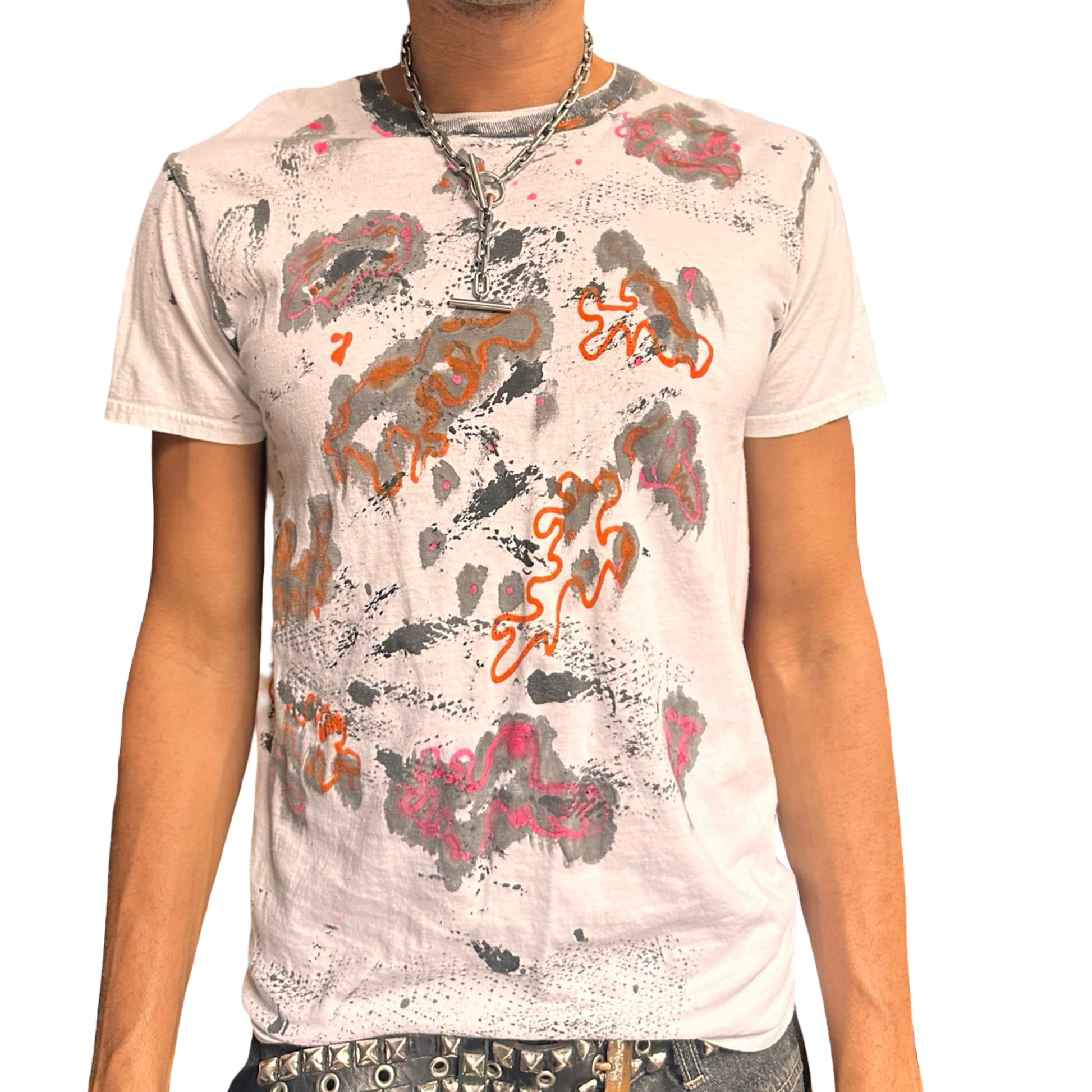 Person wearing a white t-shirt with abstract patterns on a plain background