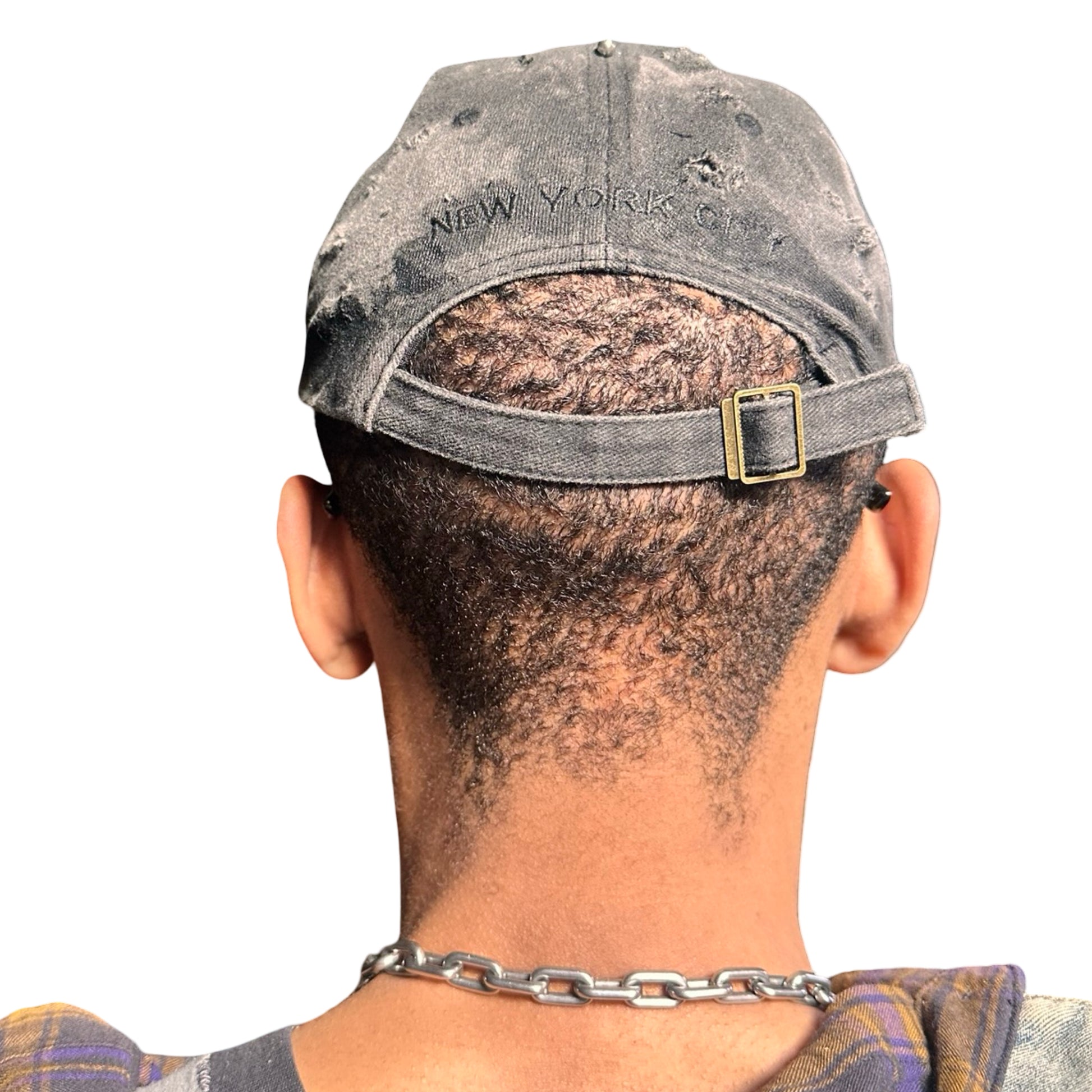 Back side of Black half-visor “New York” hat with embroidered front logo, stainless steel piercings, and an adjustable strap.
