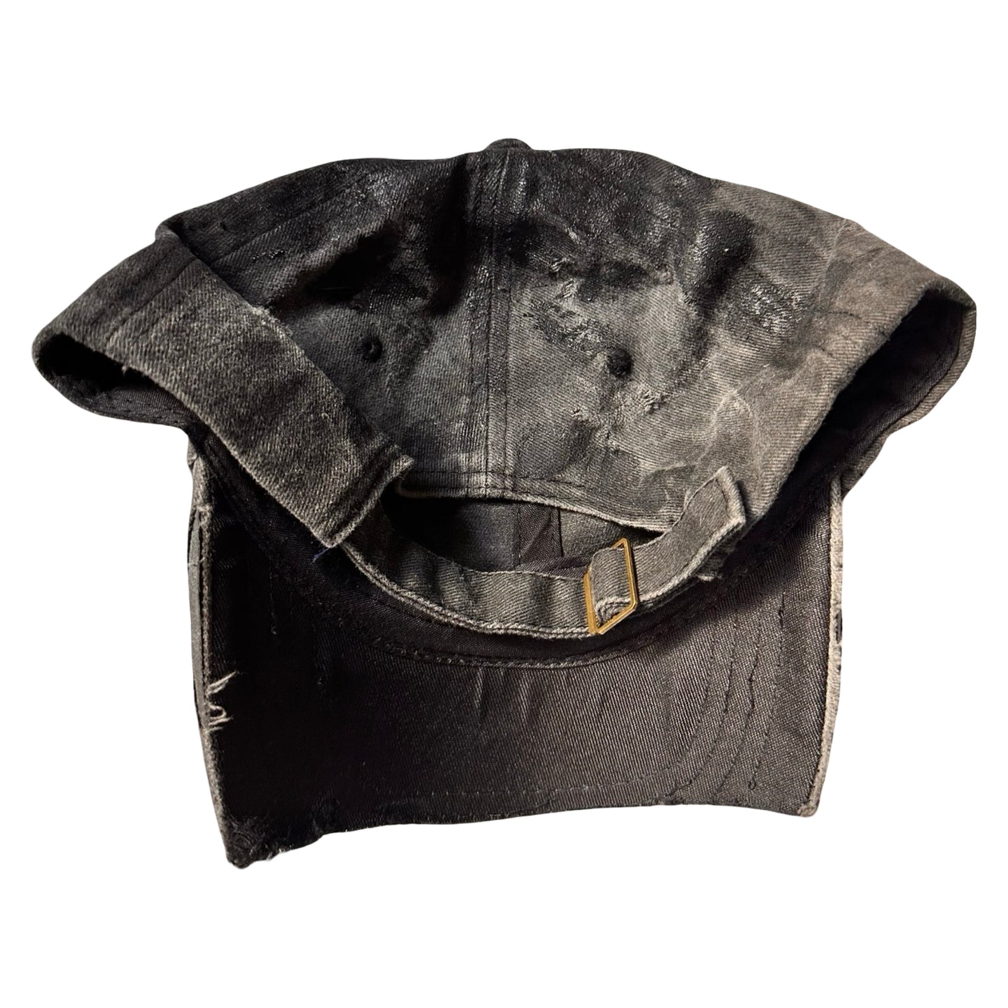Flat back of Black distressed half-visor hat with barbed-wire logo, adjustable strap, black paint details, and stainless steel piercings along the brim.