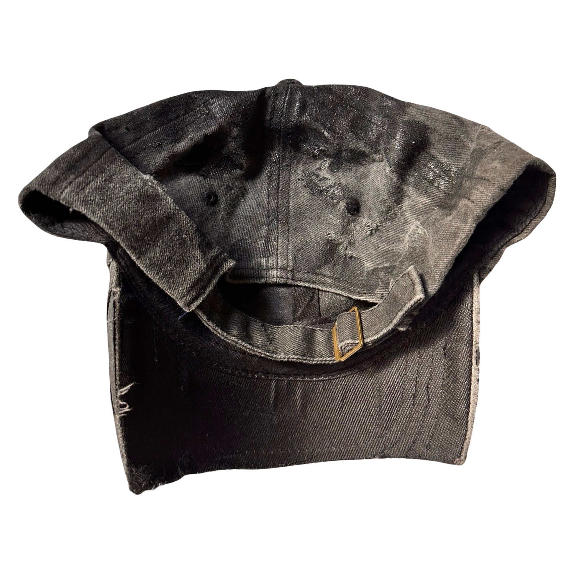 Flat back of Black distressed half-visor hat with barbed-wire logo, adjustable strap, black paint details, and stainless steel piercings along the brim.