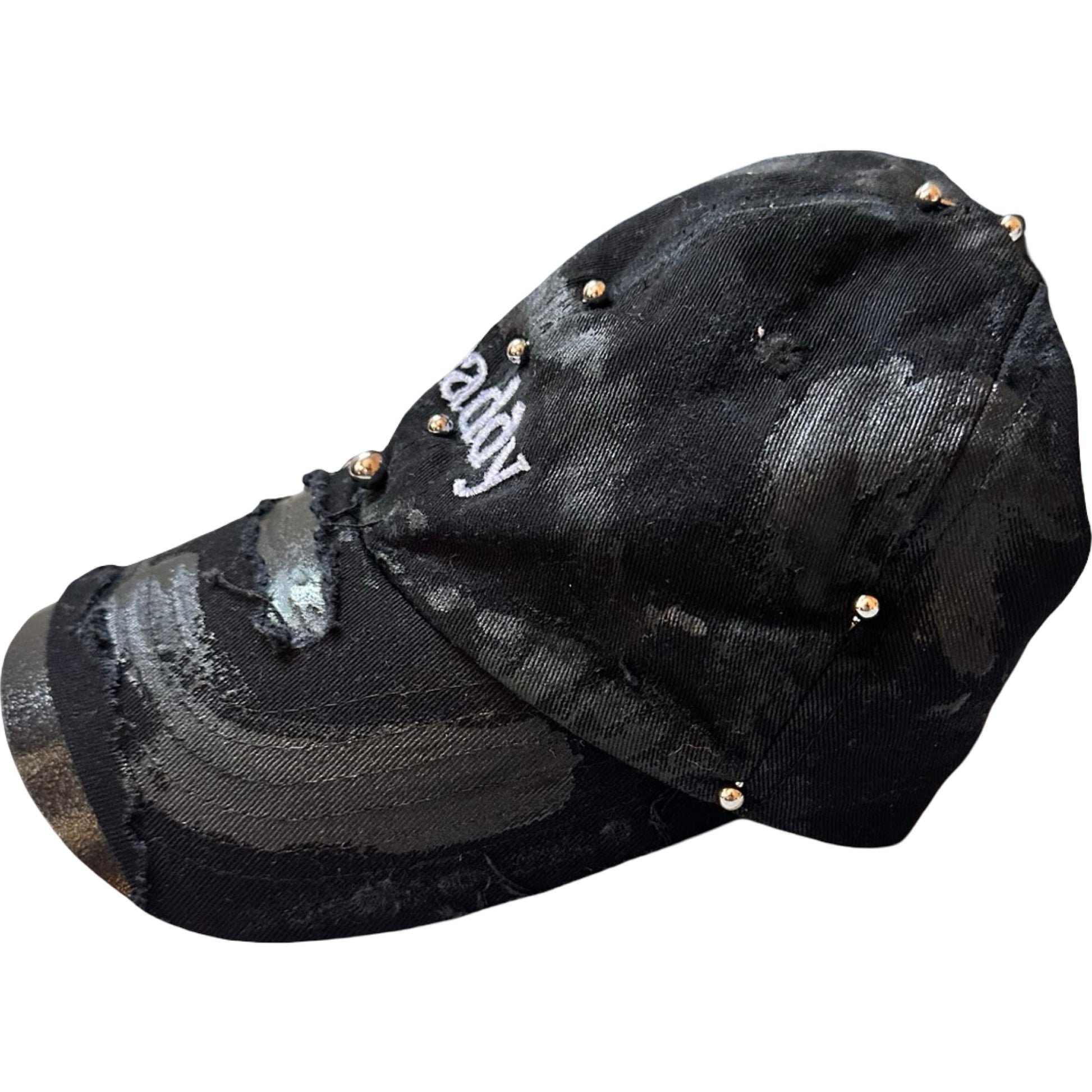 Flat left of Black distressed ASTROBOI* ‘Daddy’ hat with custom paint detailing and stainless steel piercings, handcrafted in NYC.