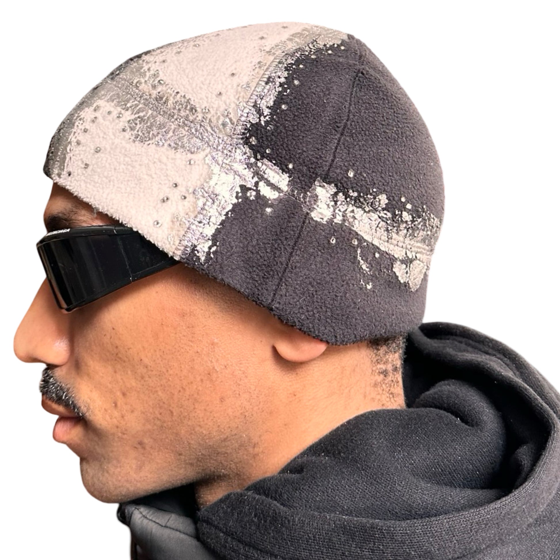 Left of ASTROBOI* black and white fleece beanie with silver rhinestone paint and tonal rhinestones. Custom handmade winter hat from ASTROBOI* STUDIO in NYC.