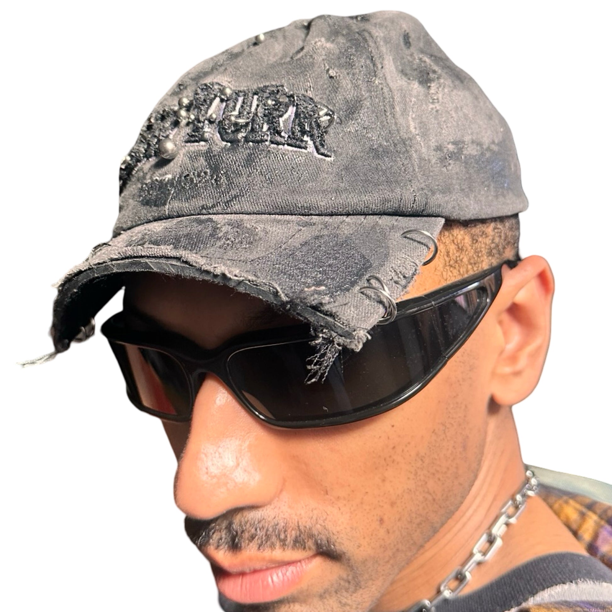 Front left side of Black half-visor “New York” hat with embroidered front logo, stainless steel piercings, and an adjustable strap.