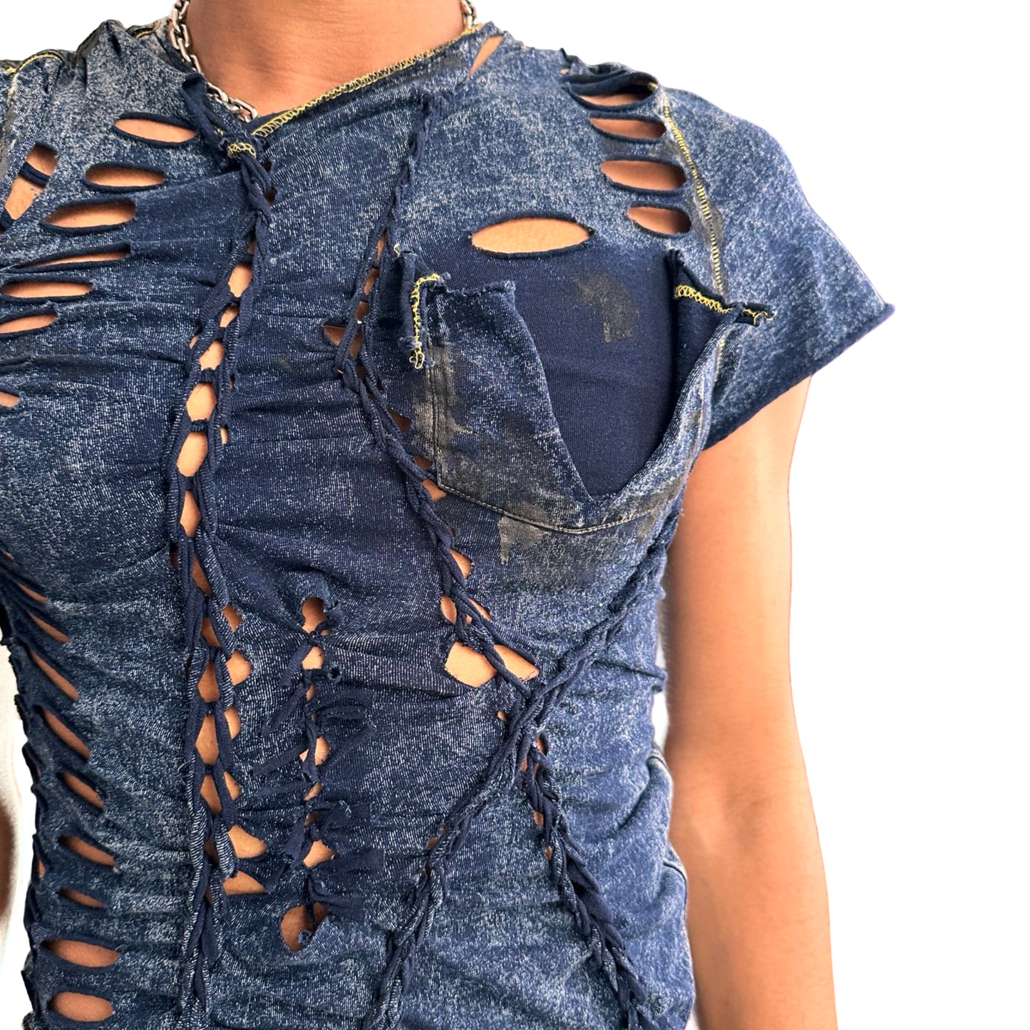 Close up of ASTROBOI* blue acid-washed braided twist T-shirt with deconstructed pocket, slashes, hole details, and black paint accents. Custom NYC streetwear.