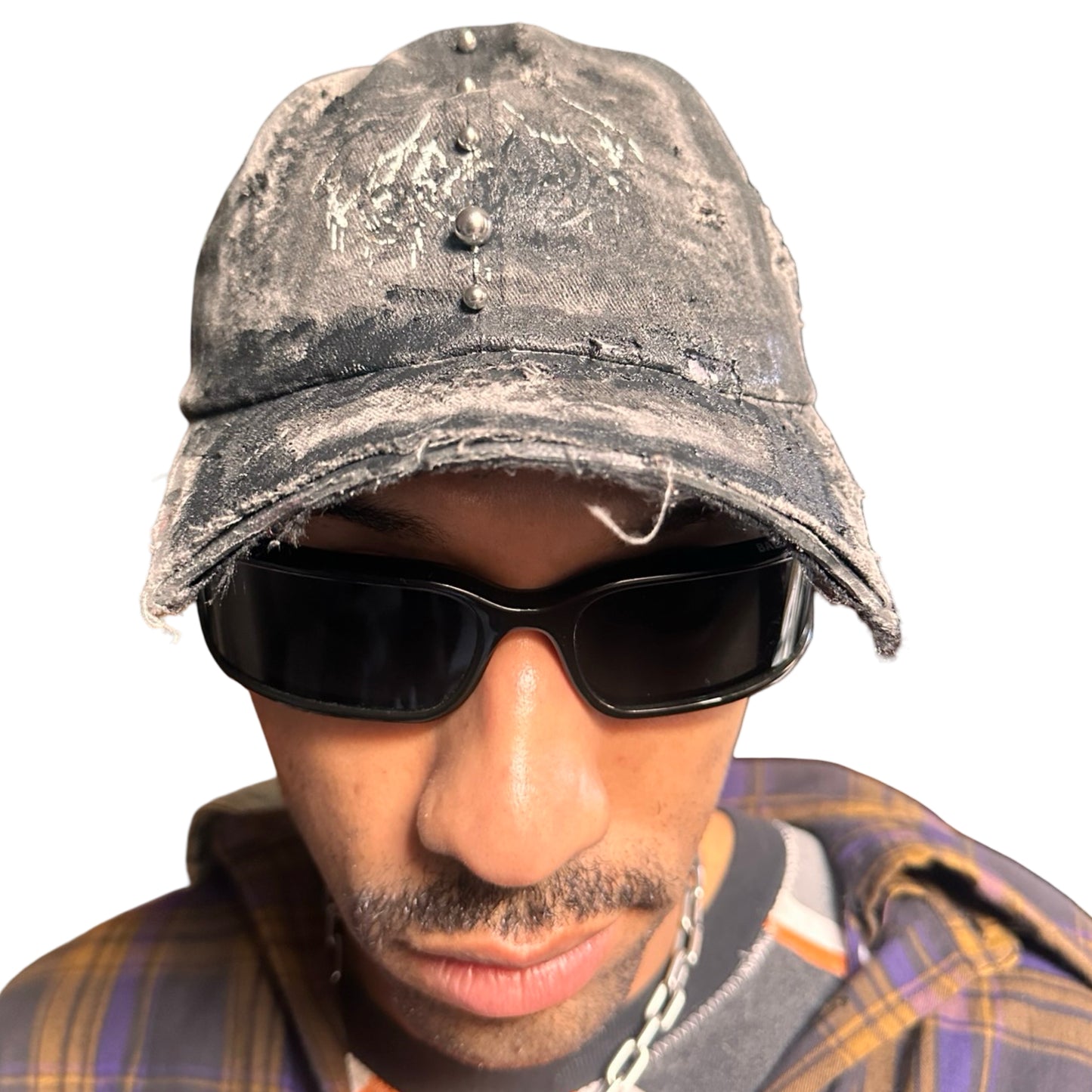 Front of Black distressed half-visor hat with barbed-wire logo, adjustable strap, black paint details, and stainless steel piercings along the brim.