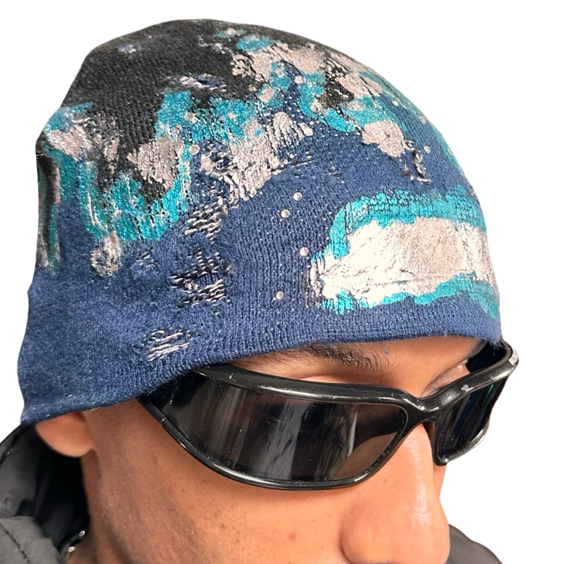 Front right of ASTROBOI* black and blue distressed flame beanie with metallic paint and tonal rhinestones. Custom acrylic knit hat handmade in NYC.