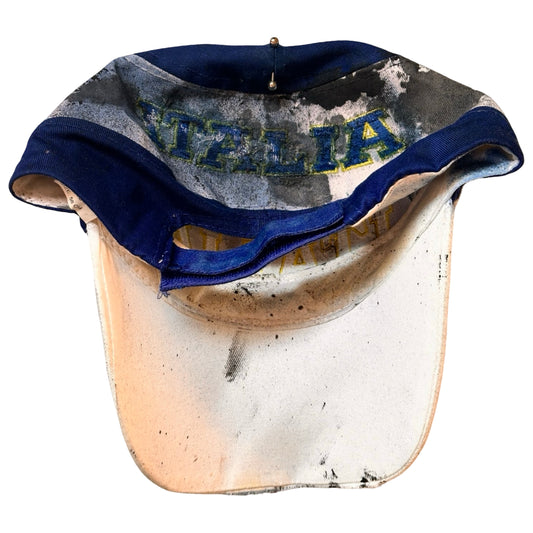 Flat back of Upcycled blue and white ASTROBOI* ‘ITALIA’ hat with rhinestones, resin, custom paint, and stainless steel piercings, handcrafted in NYC.