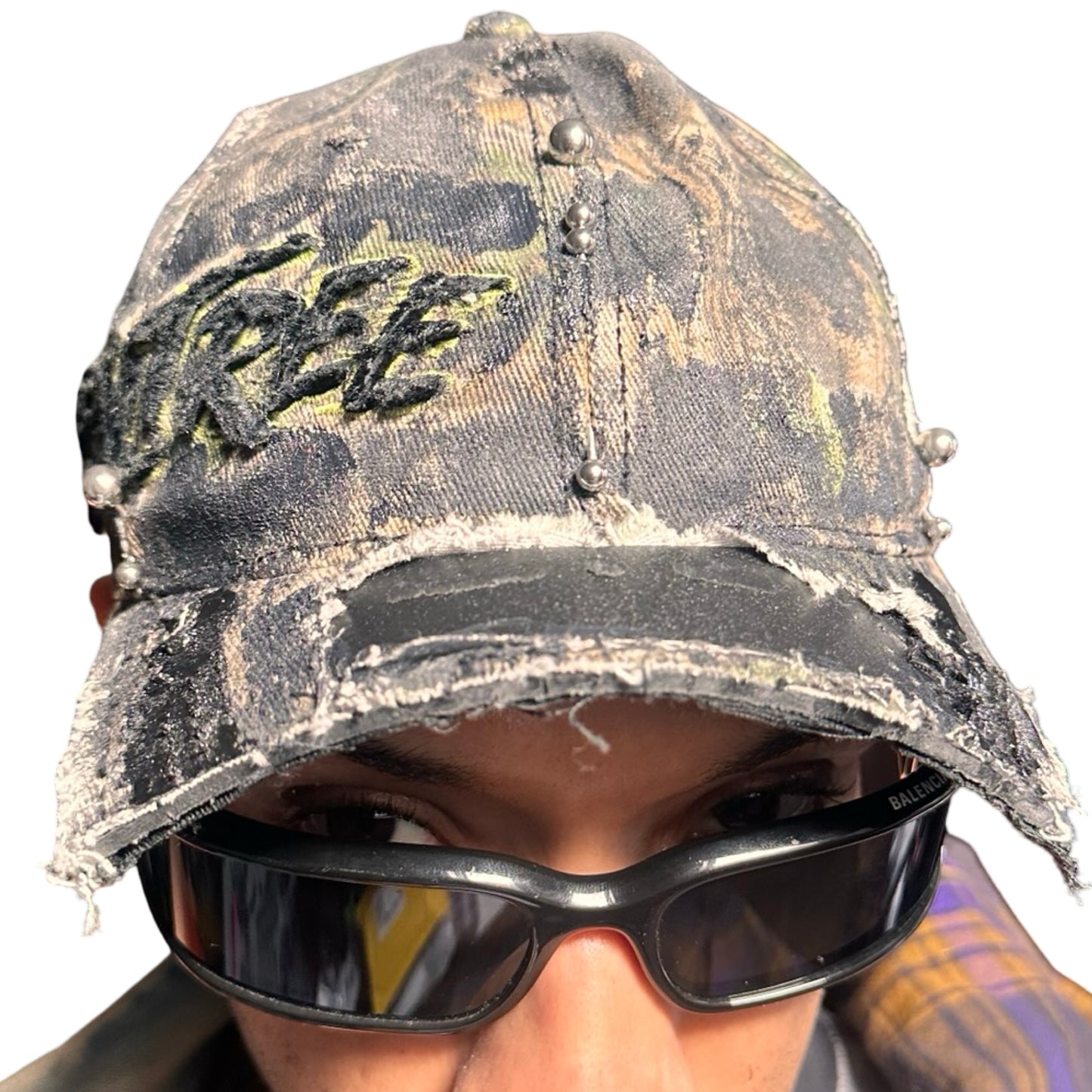 Front 2 of Brown RealTree distressed half-visor hat with elastic base, black resin detailing, and a sawed-off visor for a deconstructed Y2K aesthetic.