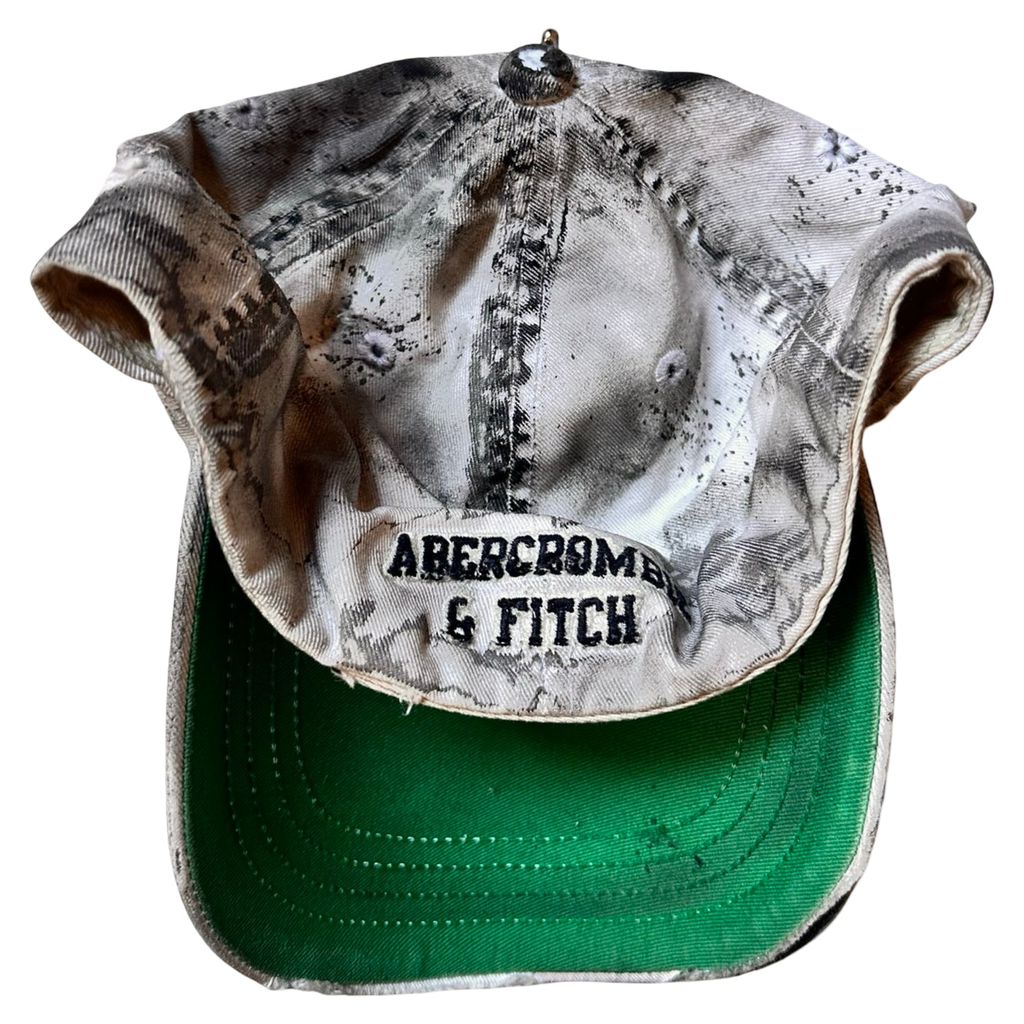 Flat back of Off-white and black faded ASTROBOI* x Abercrombie hat with custom paint treatment and stainless steel piercing, handmade in NYC.