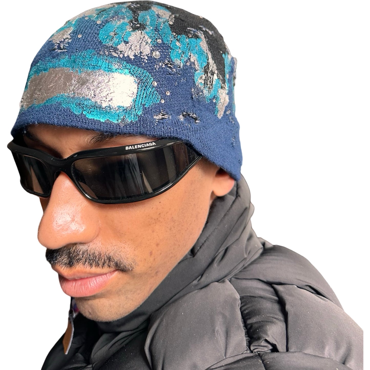 Front left of ASTROBOI* black and blue distressed flame beanie with metallic paint and tonal rhinestones. Custom acrylic knit hat handmade in NYC.