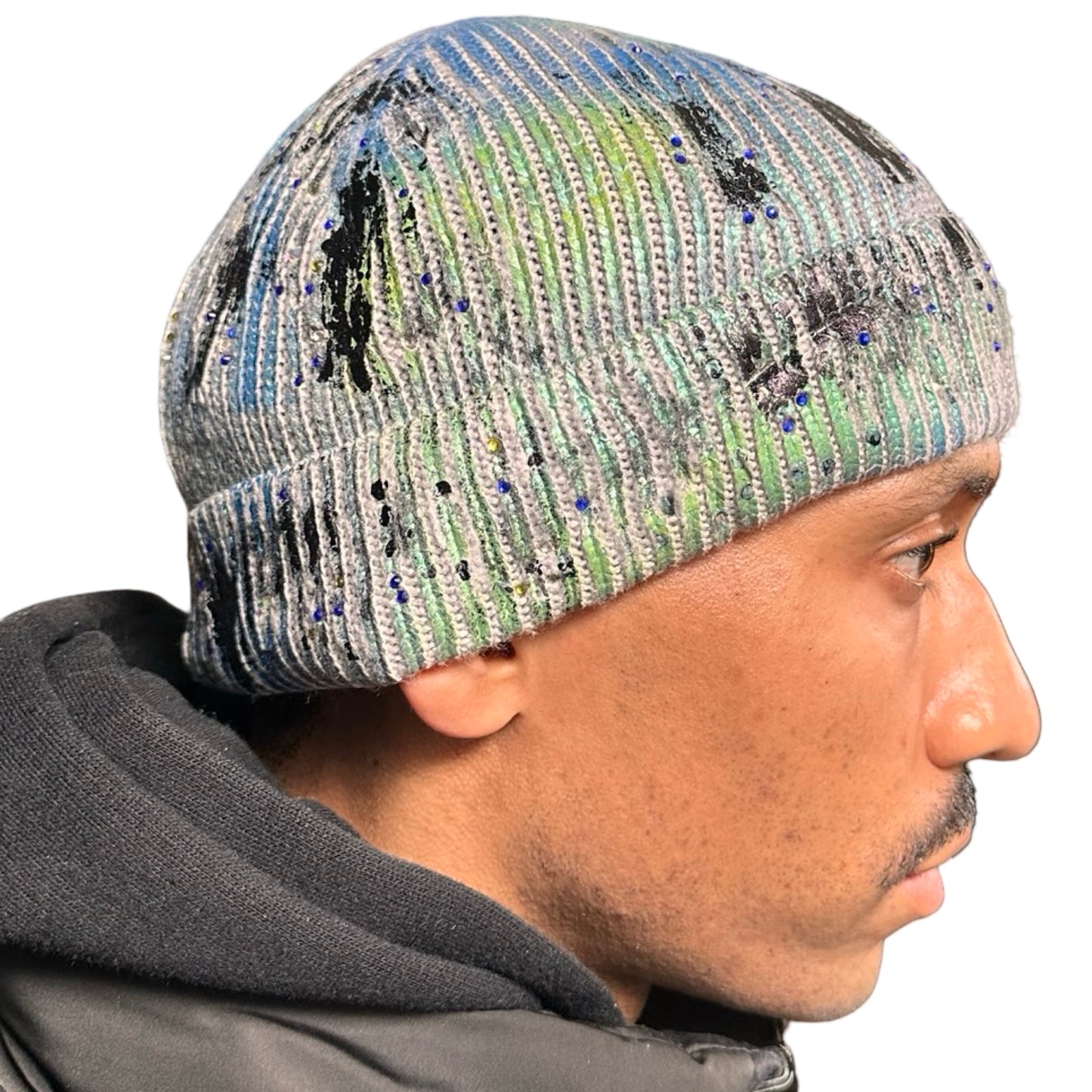 Right side of ASTROBOI* blue-green iridescent beanie featuring black metallic paint accents and tonal rhinestones, custom-made in NYC for a bold streetwear look.