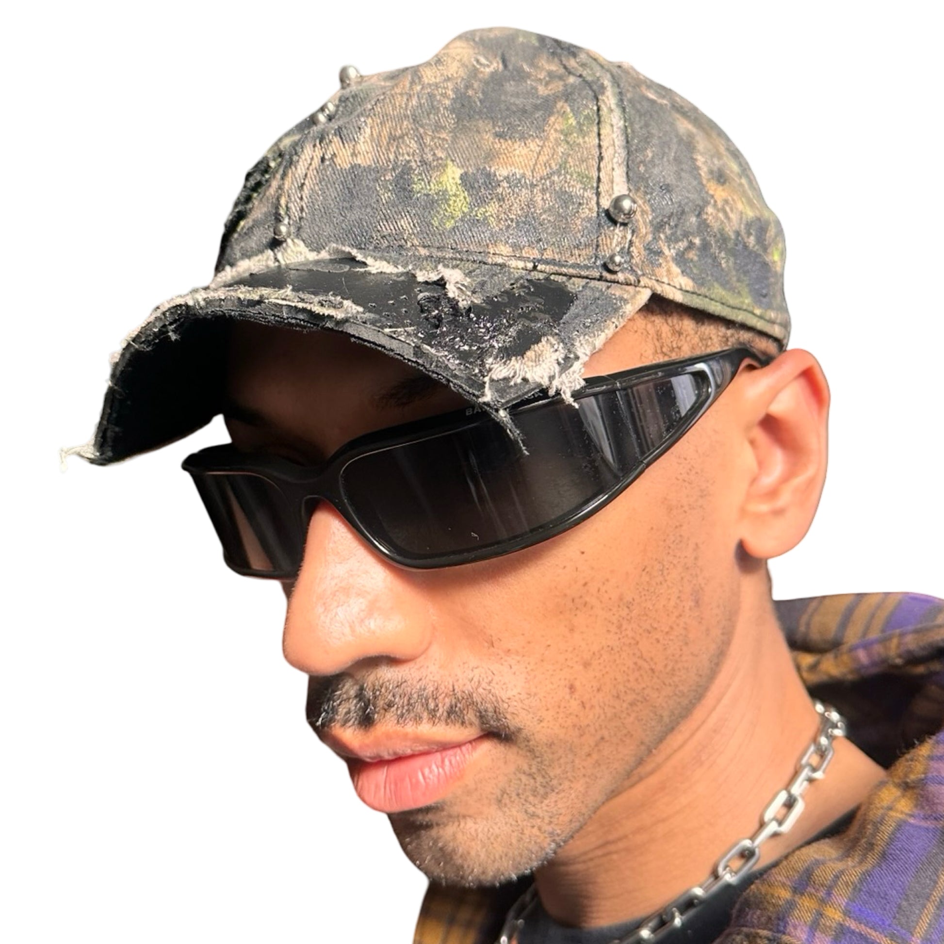 Front left side of Brown RealTree distressed half-visor hat with elastic base, black resin detailing, and a sawed-off visor for a deconstructed Y2K aesthetic.
