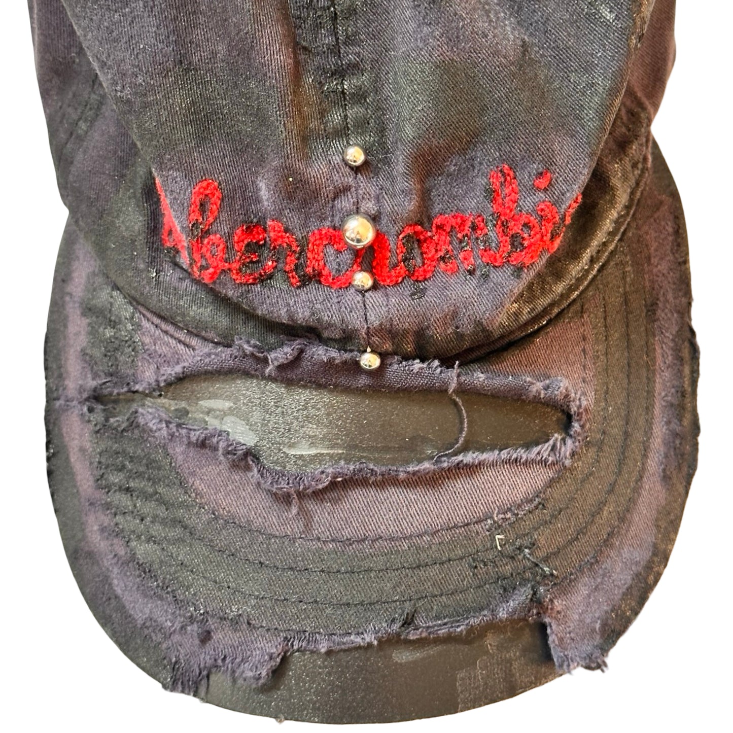 Flat front close up of Navy ASTROBOI* x Abercrombie hat with distressed paint, stainless steel piercings, and logo embroidery on front and back, customized in NYC.