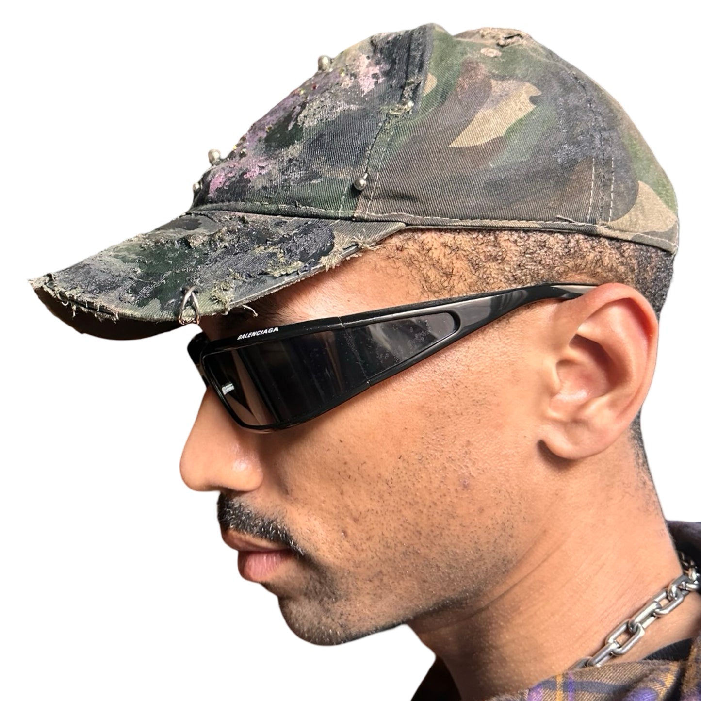 Left side of Green distressed hat with metallic rhinestones sealed in resin and stainless steel piercings, customized by ASTROBOI*.