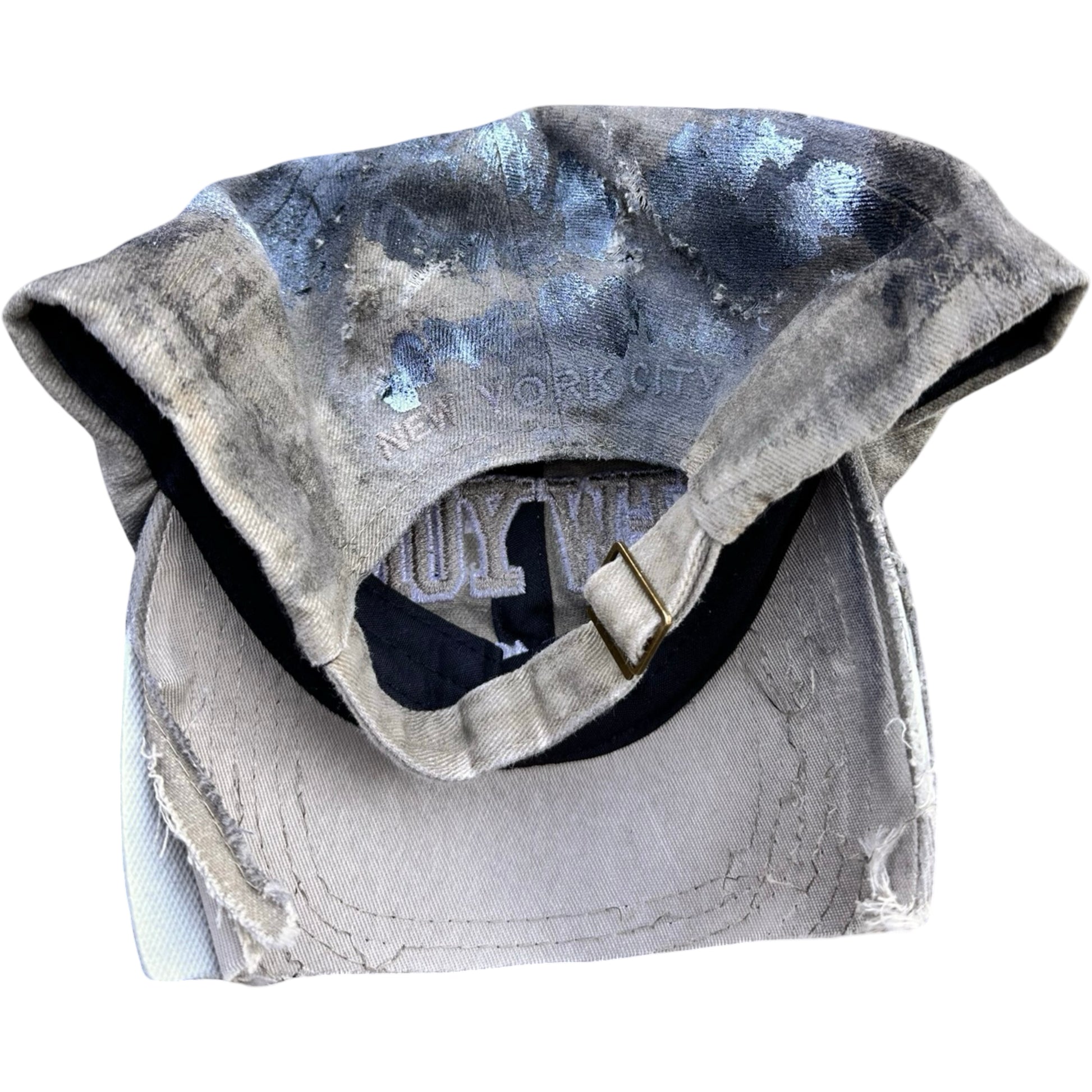 Flat back view of ASTROBOI* tan and black New York logo hat with distressed half visor and black and white paint detailing