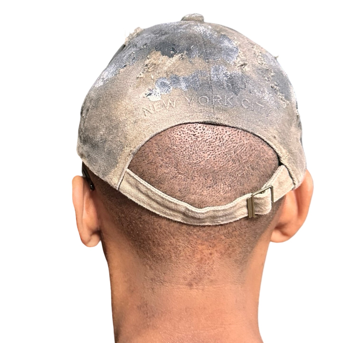 Back view of ASTROBOI* tan and black New York logo hat with distressed half visor and black and white paint detailing.