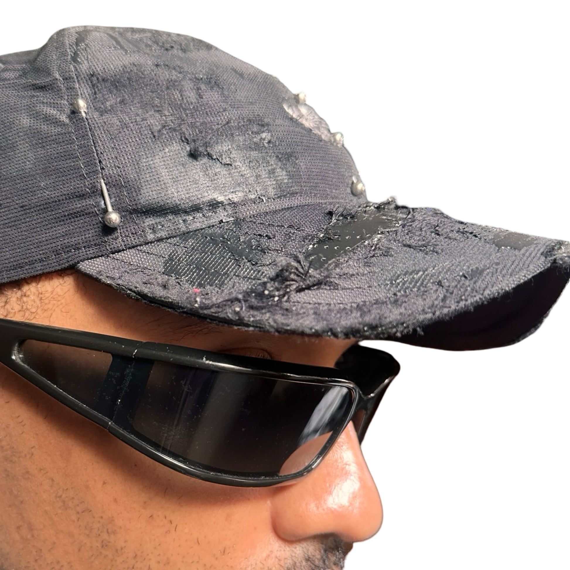 Right side close up Black Adidas hat customized by ASTROBOI* with distressing, black painted accents, and stainless steel piercings.