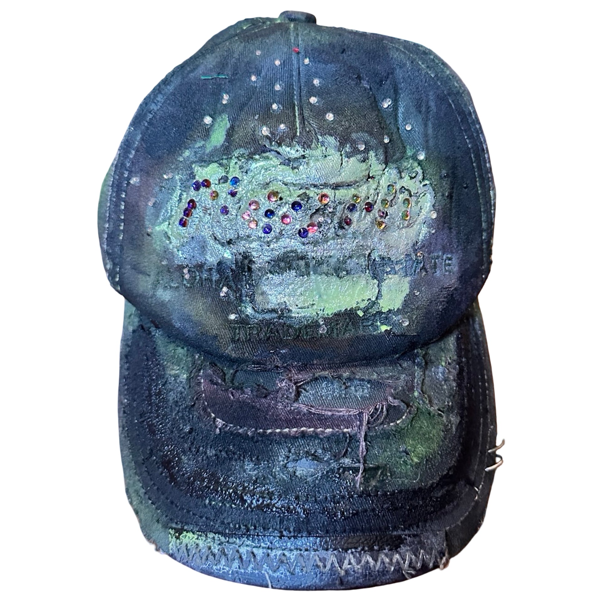 Flat front image of “Green and brown distressed ASTROBOI* Hawaii hat with rhinestones, metallic paint, and sterling-steel piercings, customized in NYC.”