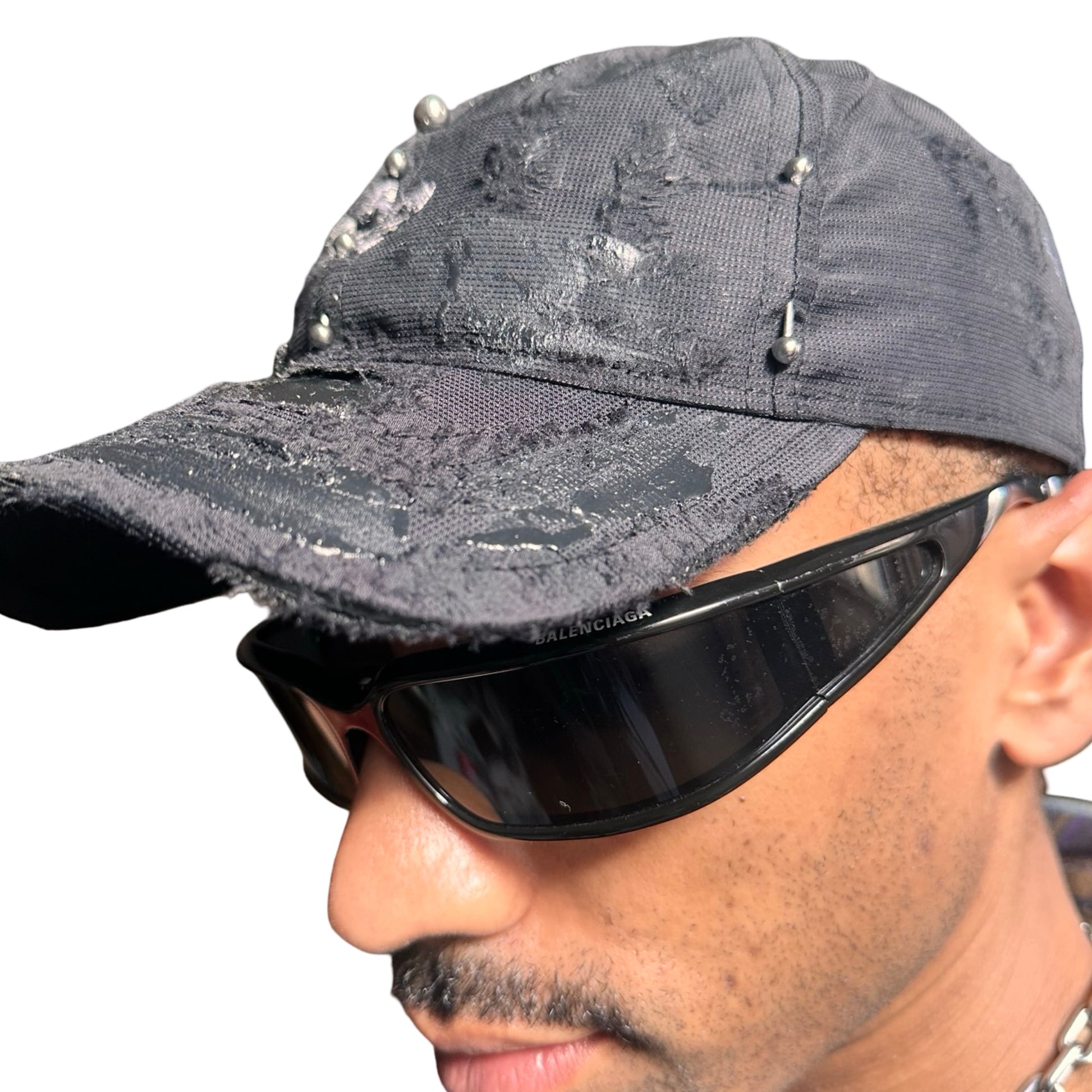 Left side detail of Black Adidas hat customized by ASTROBOI* with distressing, black painted accents, and stainless steel piercings.
